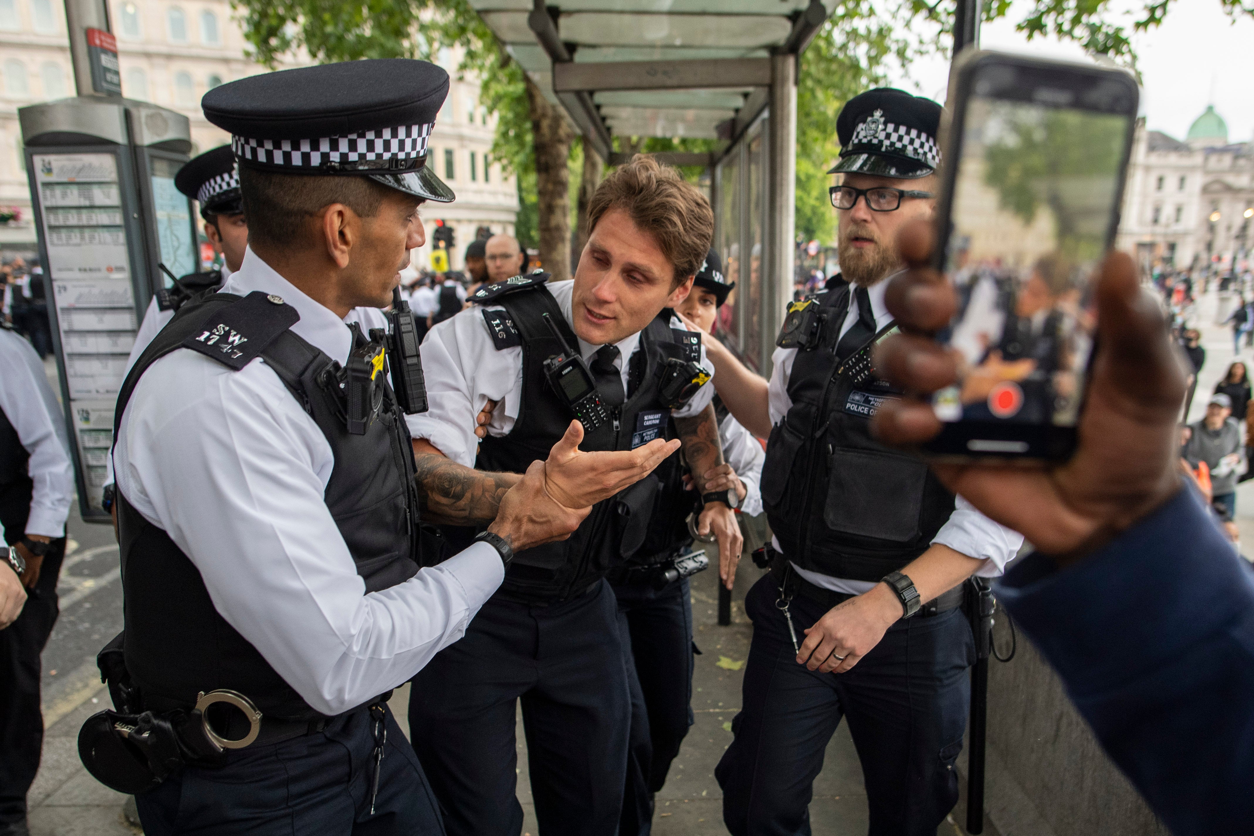 Un oficial de policía herido es asistido por sus colegas durante una protesta en Londres