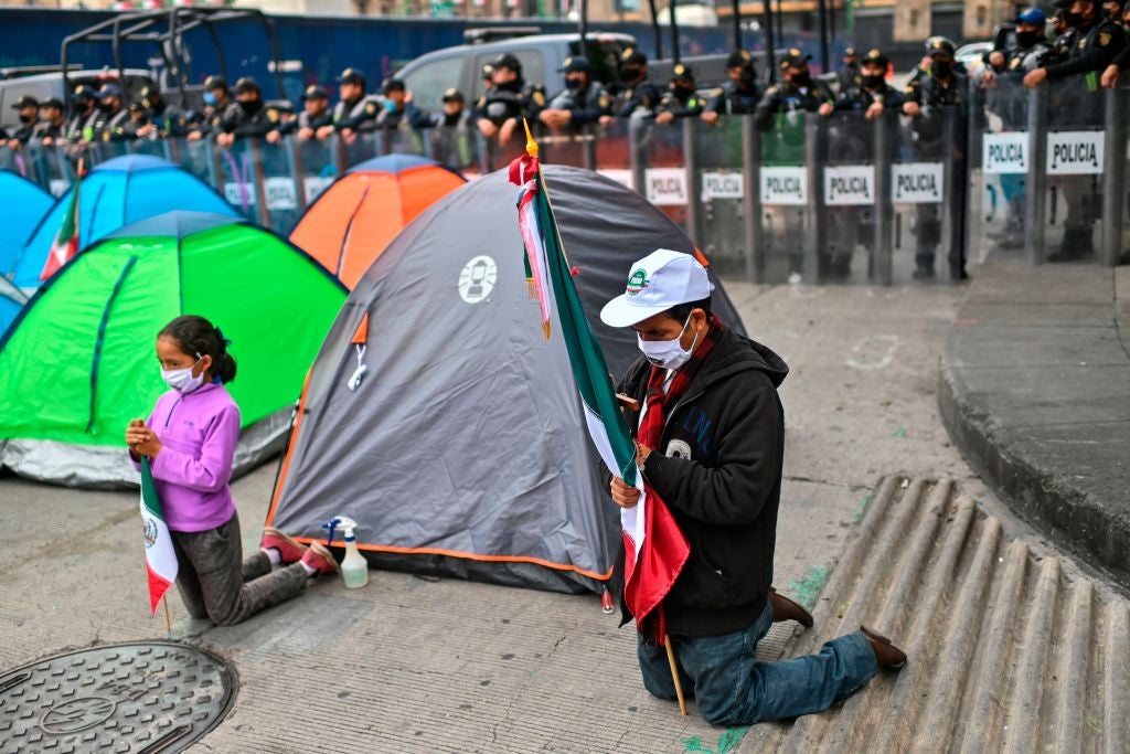 Miembros del Frente Nacional Anti-AMLO rezan luego de acampar en el centro de la Ciudad de México.