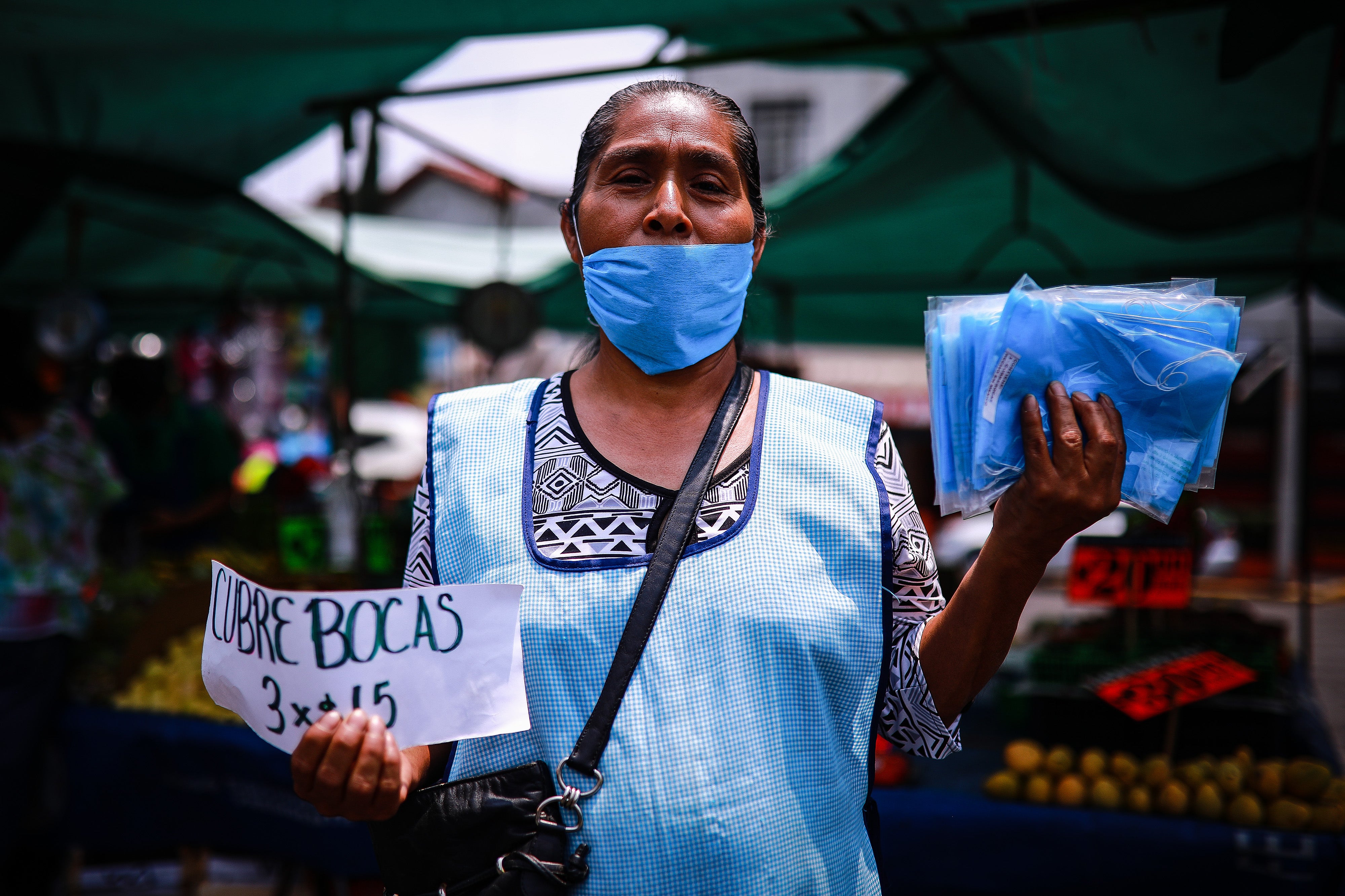 Mujer vende cubrebocas en México durante pandemia por coronavirus.