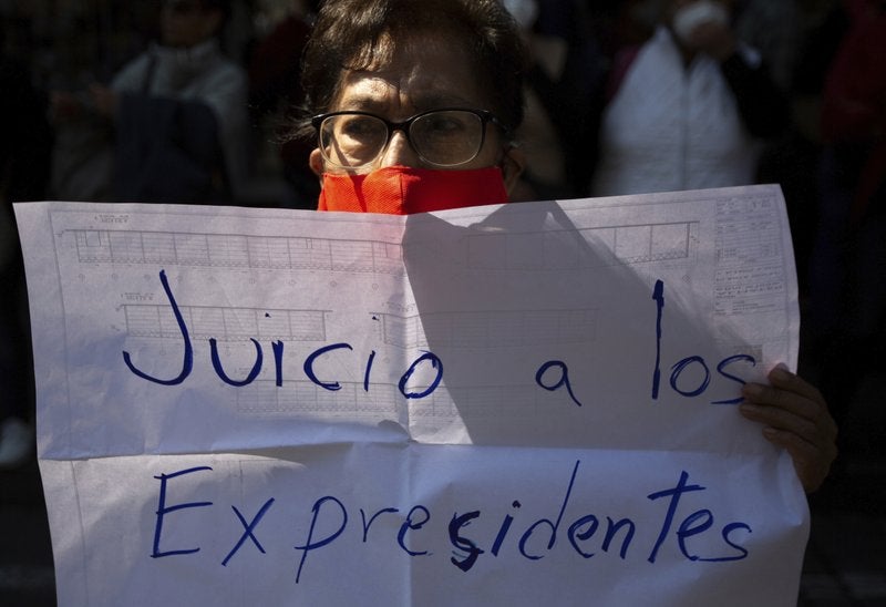 Un partidario del presidente de México, Andrés Manuel López Obrador, sostiene una pancarta con el mensaje "Juicio a los expresidentes" durante una manifestación frente a la Corte Suprema en la Ciudad de México, el jueves 1 de octubre de 2020.