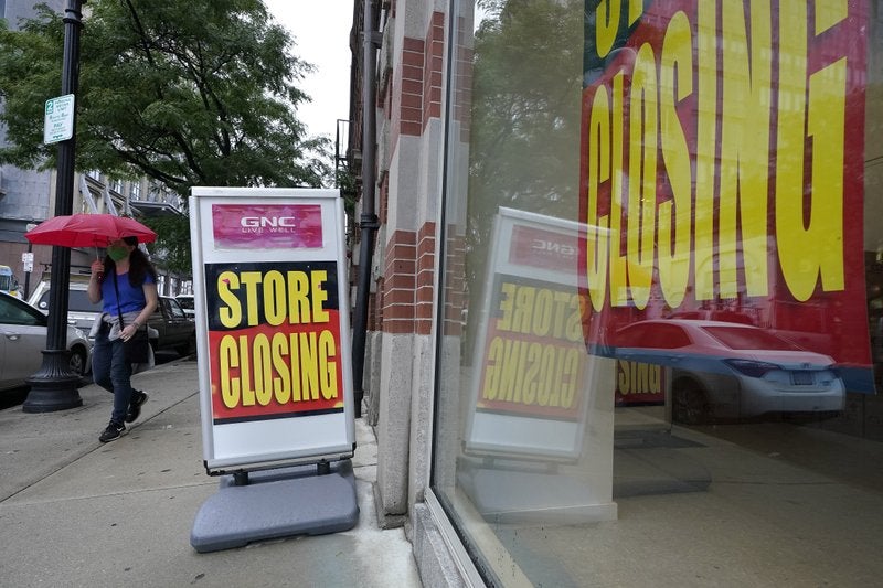 En esta foto un transeúnte pasa junto a un aviso de cierre de negocio en Boston. (Foto/Steven Senne)