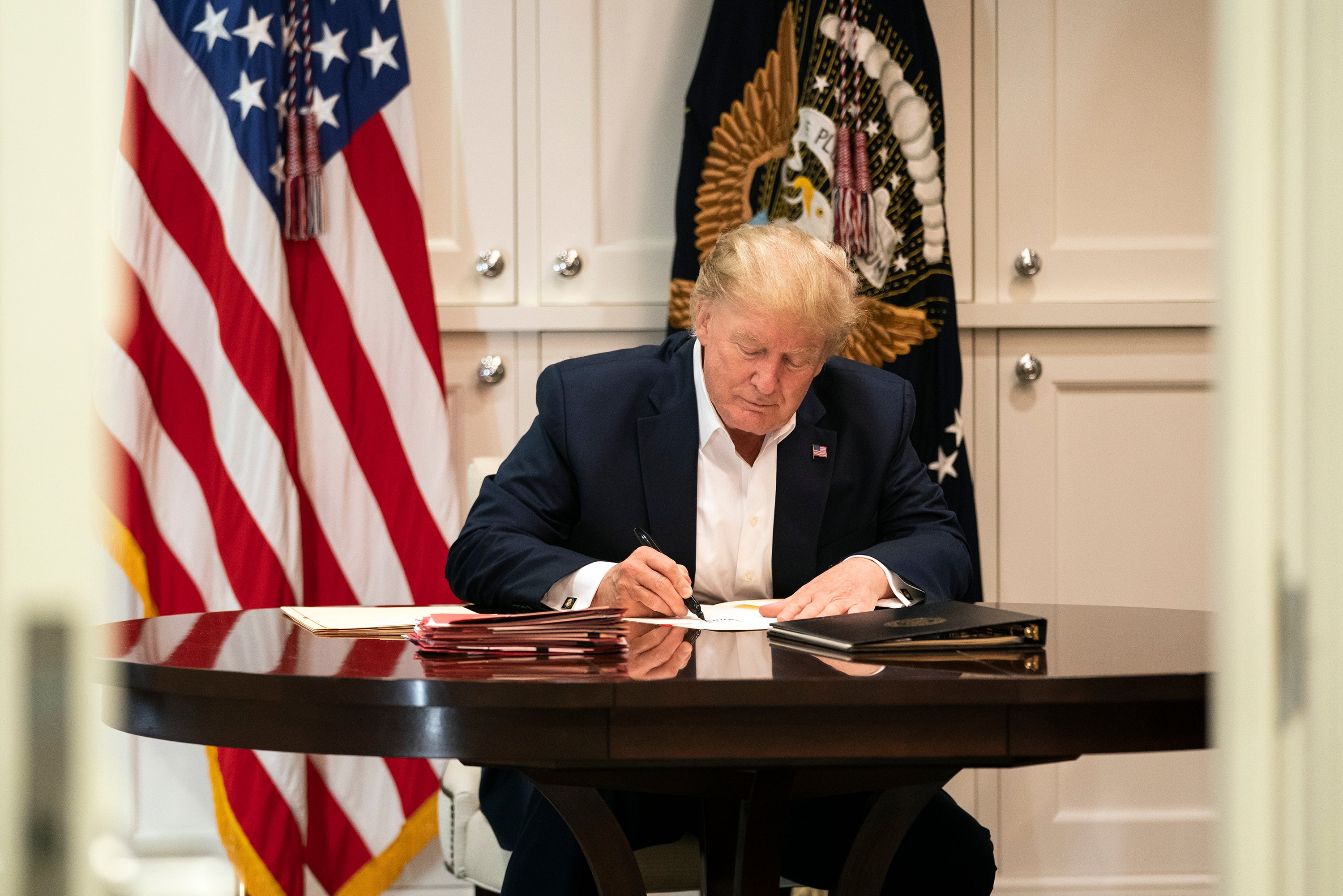 Se burlan de foto de Trump en la que aparece firmando un papel aparentemente en blanco