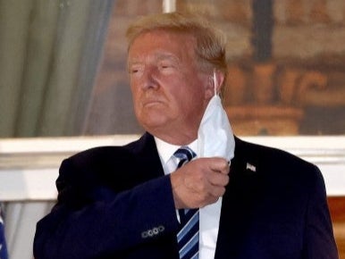 Donald Trump se quita la mascarilla en su llegada a la Casa Blanca.