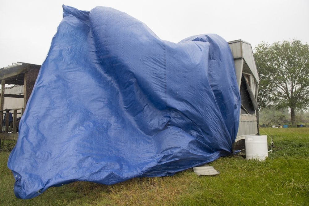 Una lona azul colocada sobre una casa destruida parcialmente por el huracán Laura hace unas semanas es agitada por los vientos creados por el huracán Delta en el sur de Luisiana el viernes 9 de octubre de 2020. (Chris Granger/The Advocate vía AP)
