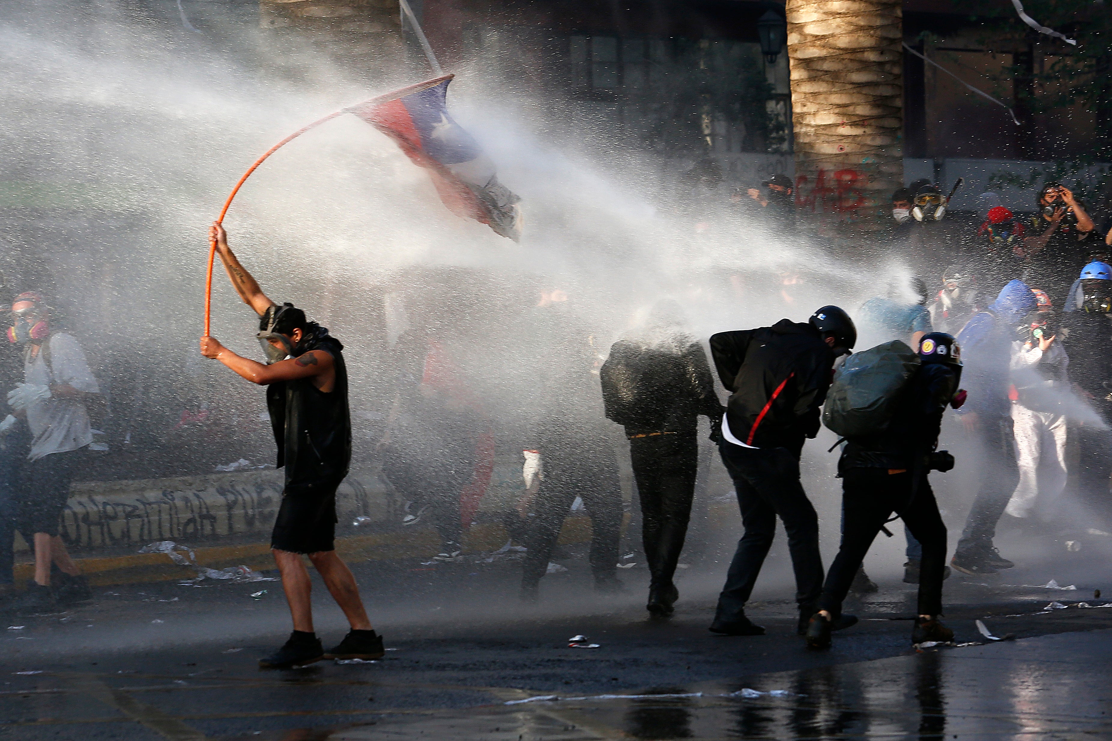 Manifestantes antigubernamentales son reprimidos con cañones de agua de la policía durante una protesta en Santiago de Chile, el viernes 9 de octubre de 2020
