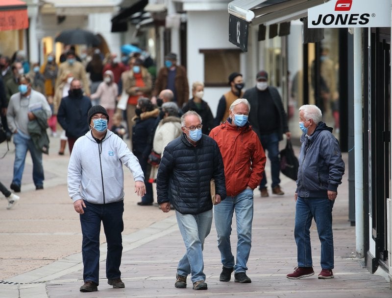 Personas con máscaras debido al coronavirus caminan por una calle en Saint Jean de Luz, Francia.
