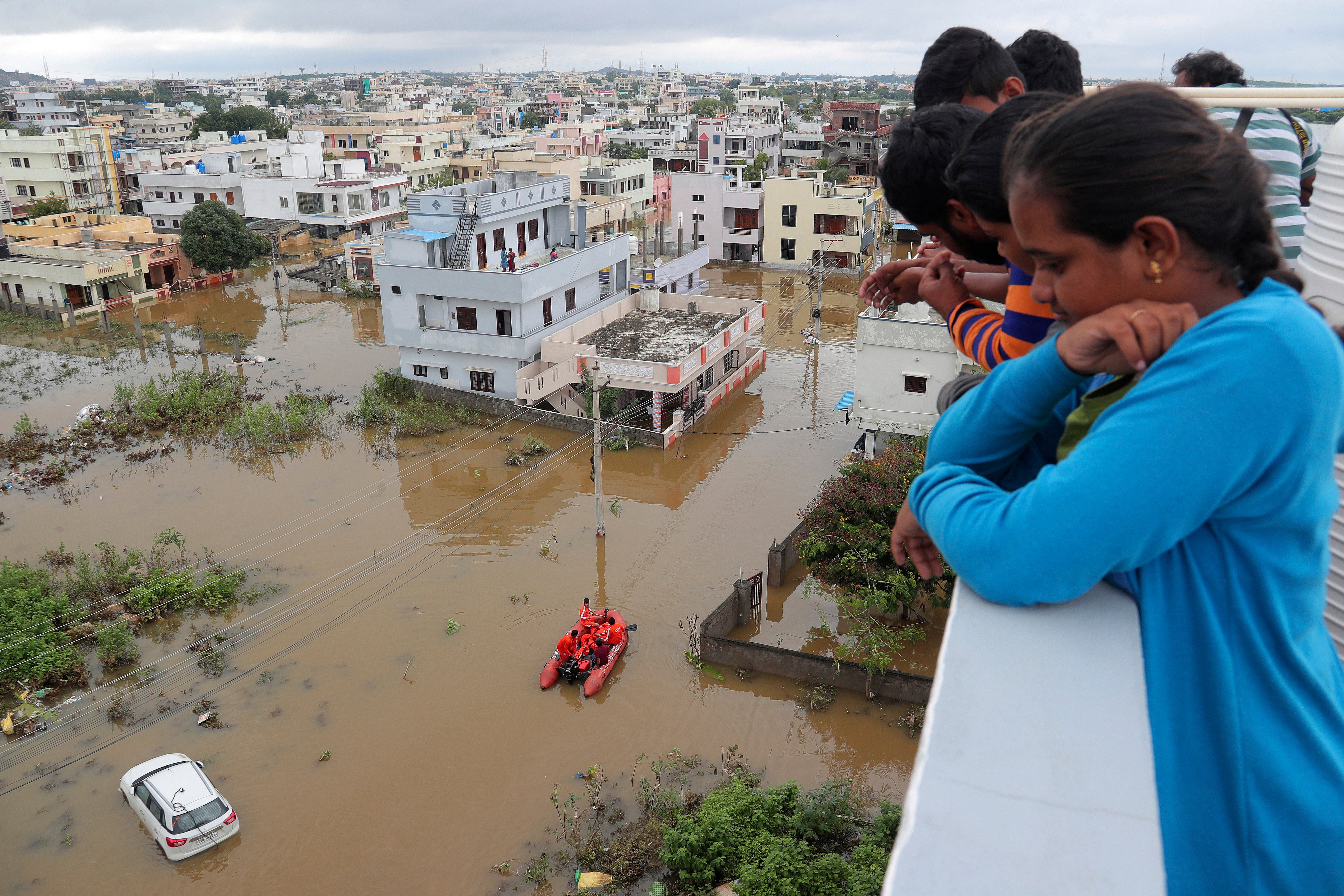 Los residentes miran una calle inundada por las inundaciones después de las fuertes lluvias en Hyderabad, India