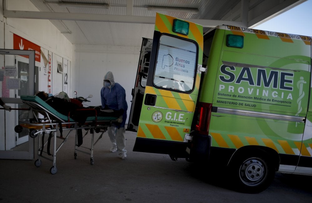 Trabajadores de la salud llevan a un paciente en camilla a un hospital para enfermos de COVID-19 en Mar del Plata, Argentina.