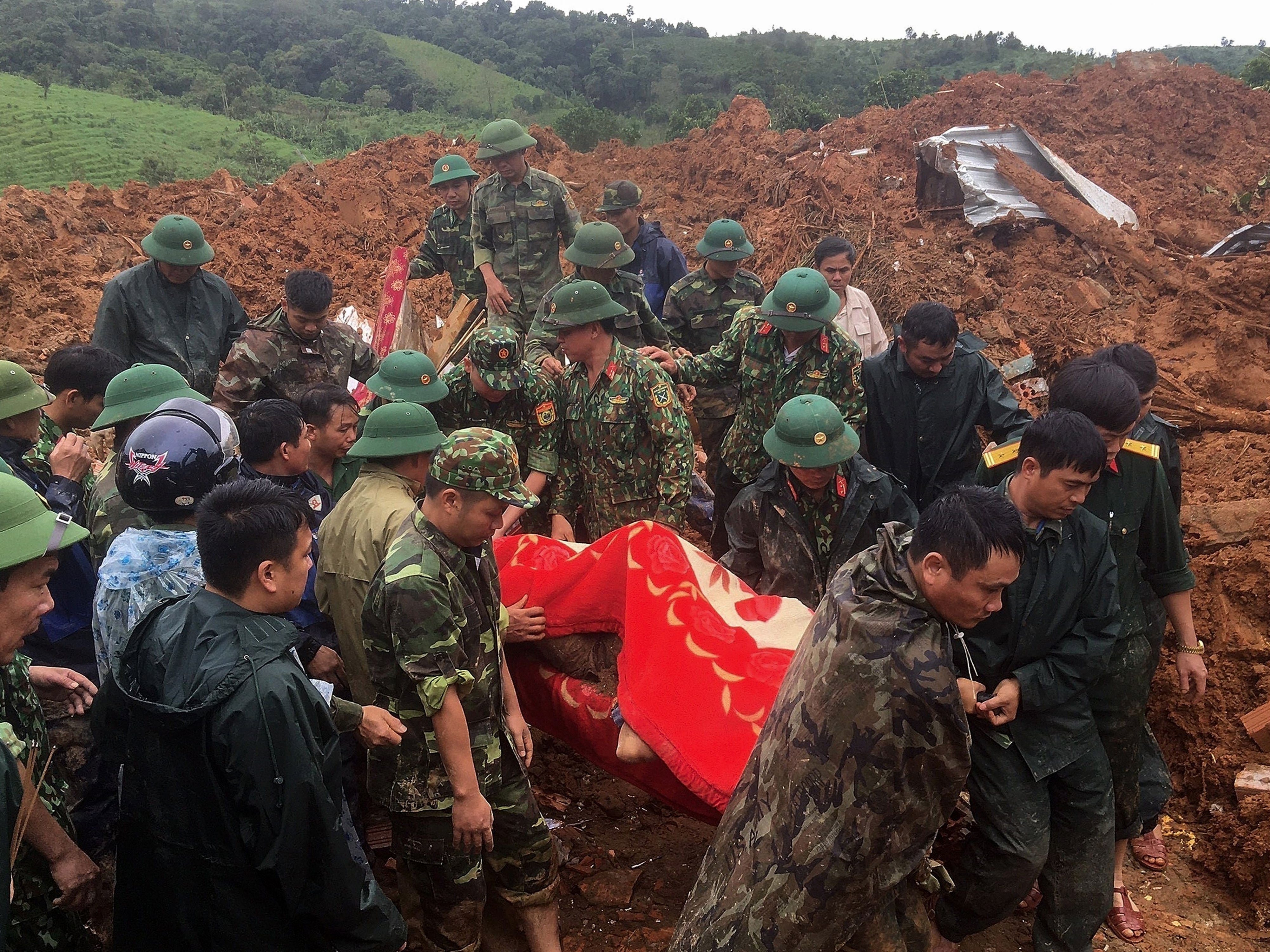 Personal militar portando un cuerpo recuperado del lugar de un deslizamiento de tierra en la provincia de Quang Tri, en el centro de Vietnam.