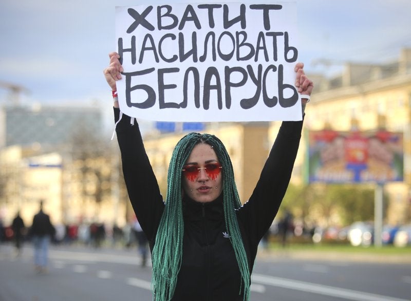 Una manifestante muestra un cartel con la leyenda "Dejen de violar Bielorrusia", durante una marcha contra el presidente Alexander Lukashenko