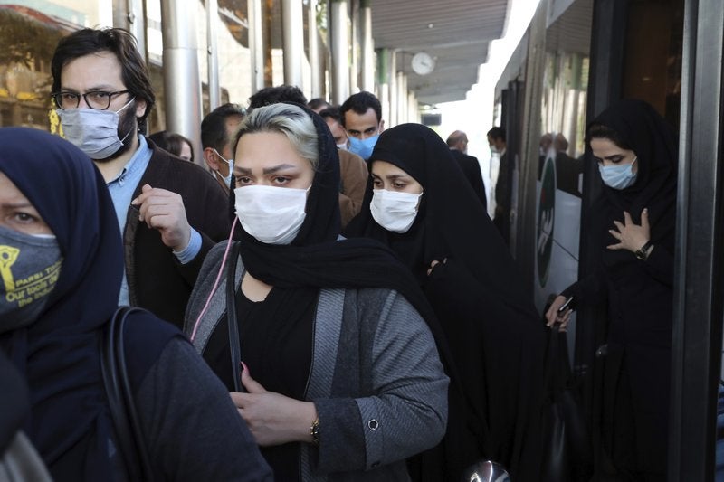 Un grupo de personas usa cubrebocas a su llegada al centro de la capital Teherán.