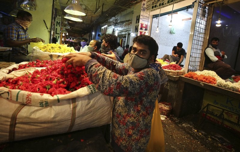 Vendedores colocan flores en un mercado al por mayor antes del festival hindú del Dussehra, en Bengaluru, India.