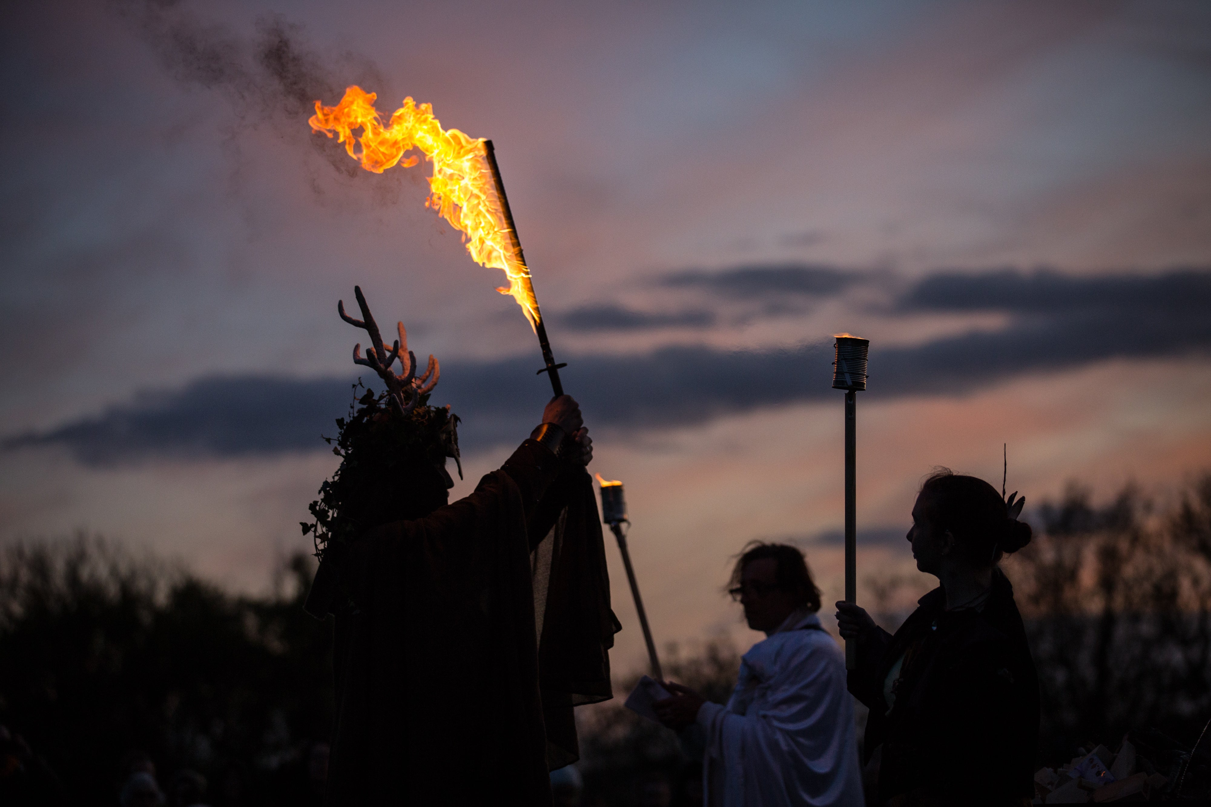 Un hombre que representa al Rey del Invierno sostiene una espada en llamas durante una ceremonia en Glastonbury para celebrar Samhain