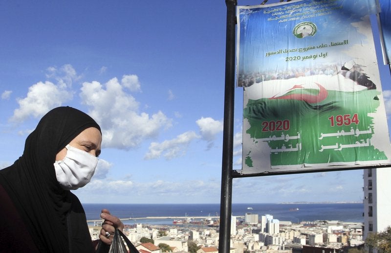 Una mujer pasa junto a carteles llamando al voto en un referendo, el martes 27 de octubre de 2020 en Argel.