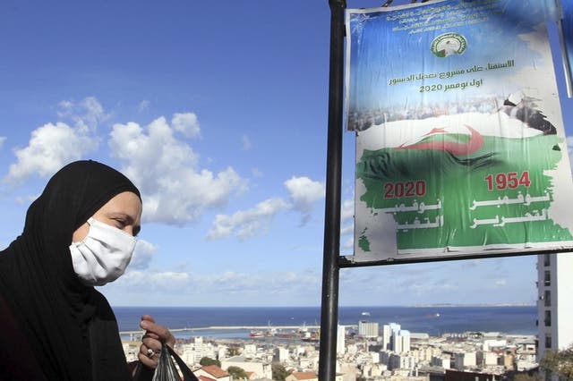 Una mujer pasa junto a carteles llamando al voto en un referendo, el martes 27 de octubre de 2020 en Argel.