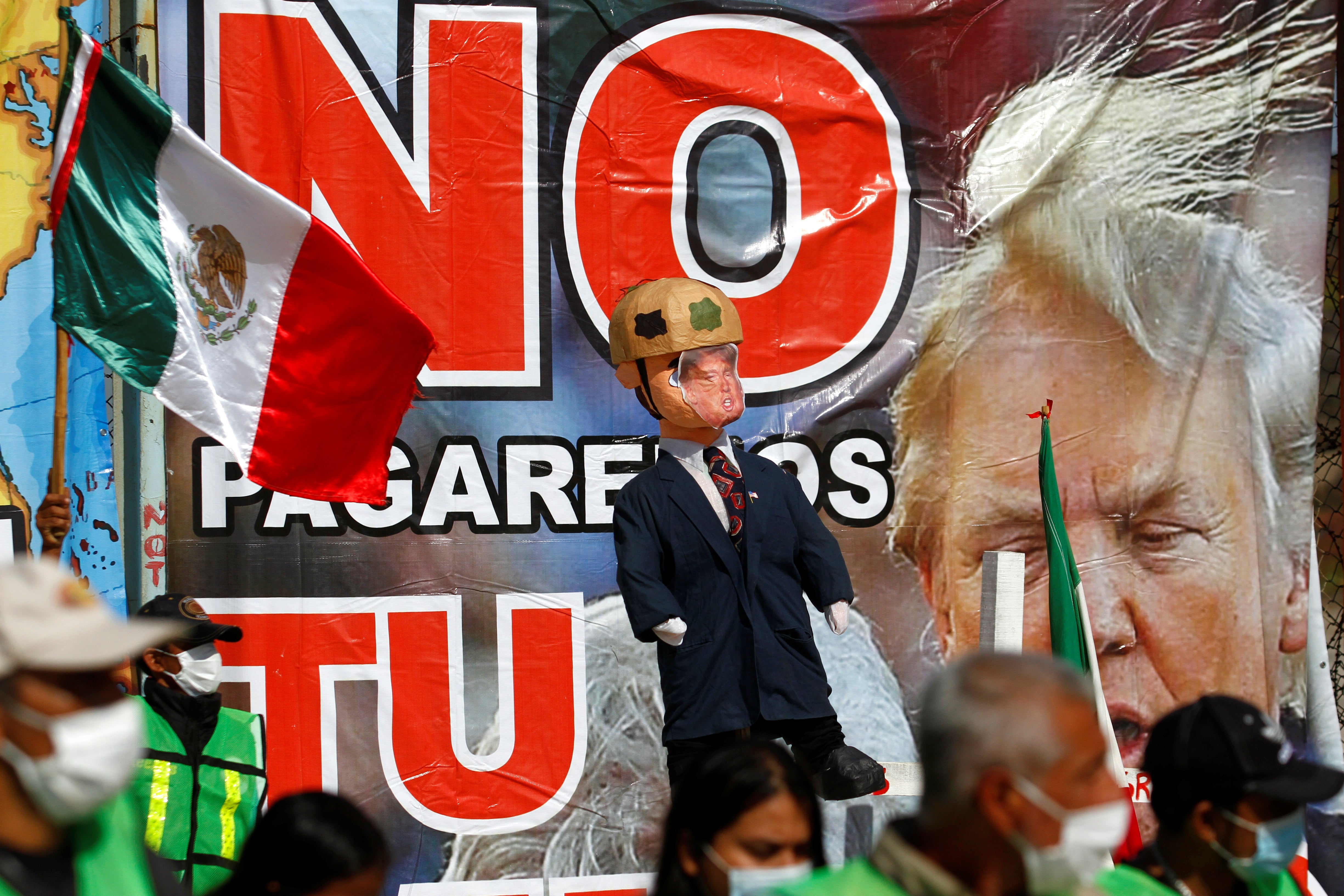 Migrantes sostienen una piñata con la imagen del presidente de los Estados Unidos, Donald Trump.