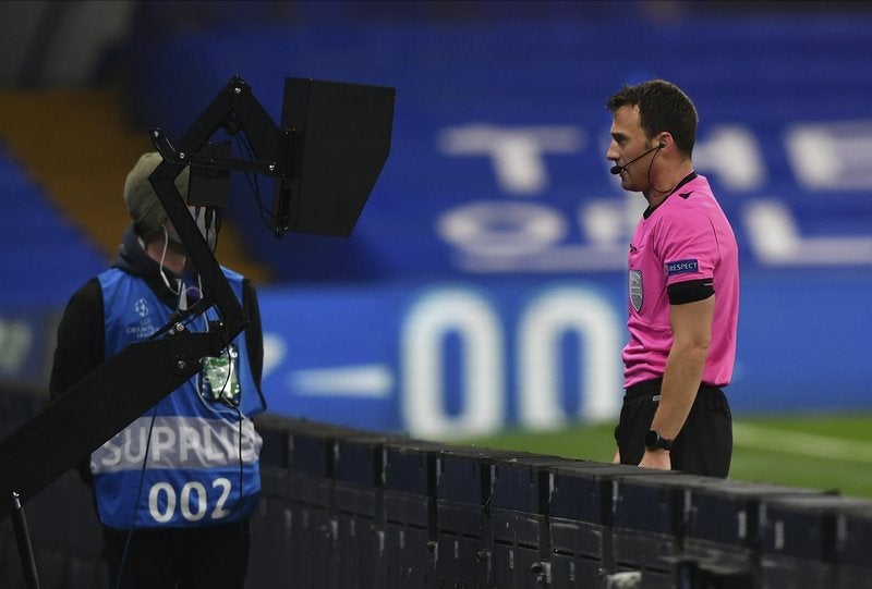 El árbitro observa un incidente en el VAR previo a señalar un penal en el partido de la Liga de Campeones entre Chelsea y Rennes.