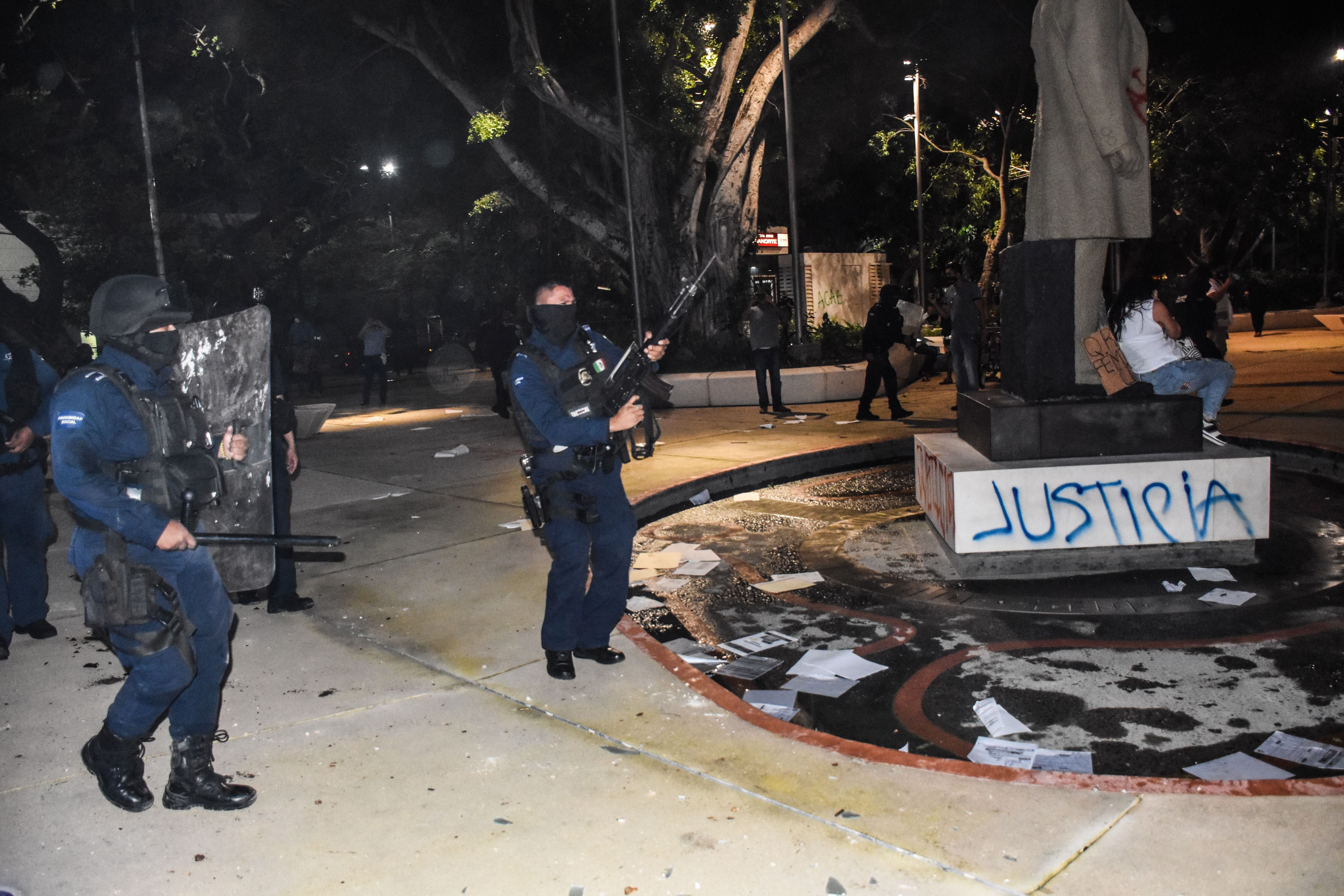 Oficiales de policía dispersan una protesta contra el asesinato de una mujer en una esquina del Palacio municipal en Cancún, Quintana Roo, México, el 9 de Noviembre de 2020.-