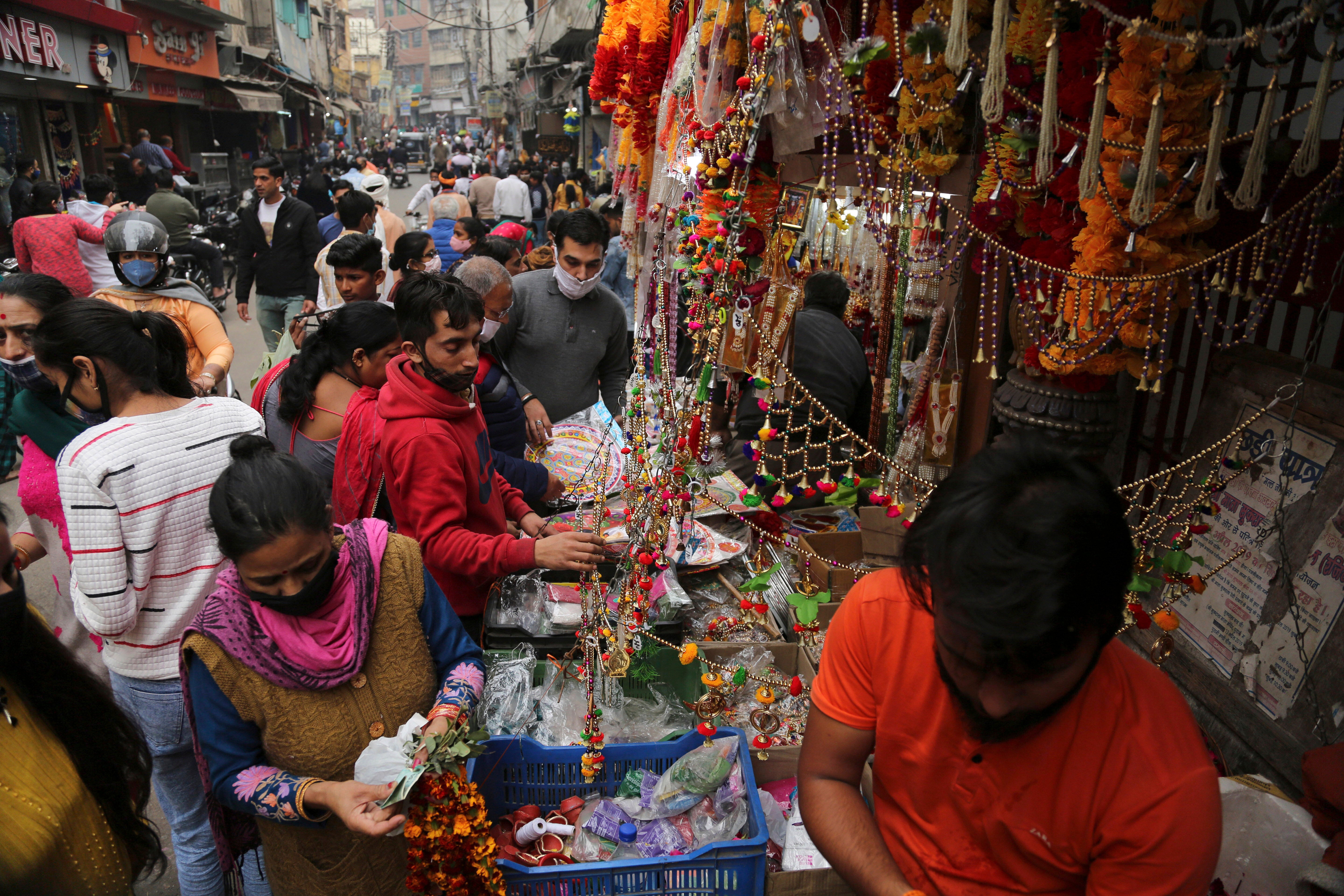 Indios con mascarillas como medida de precaución contra el coronavirus compran durante el Diwali, el festival indio de la luz, en Jammu, India, el sábado 14 de noviembre de 2020.