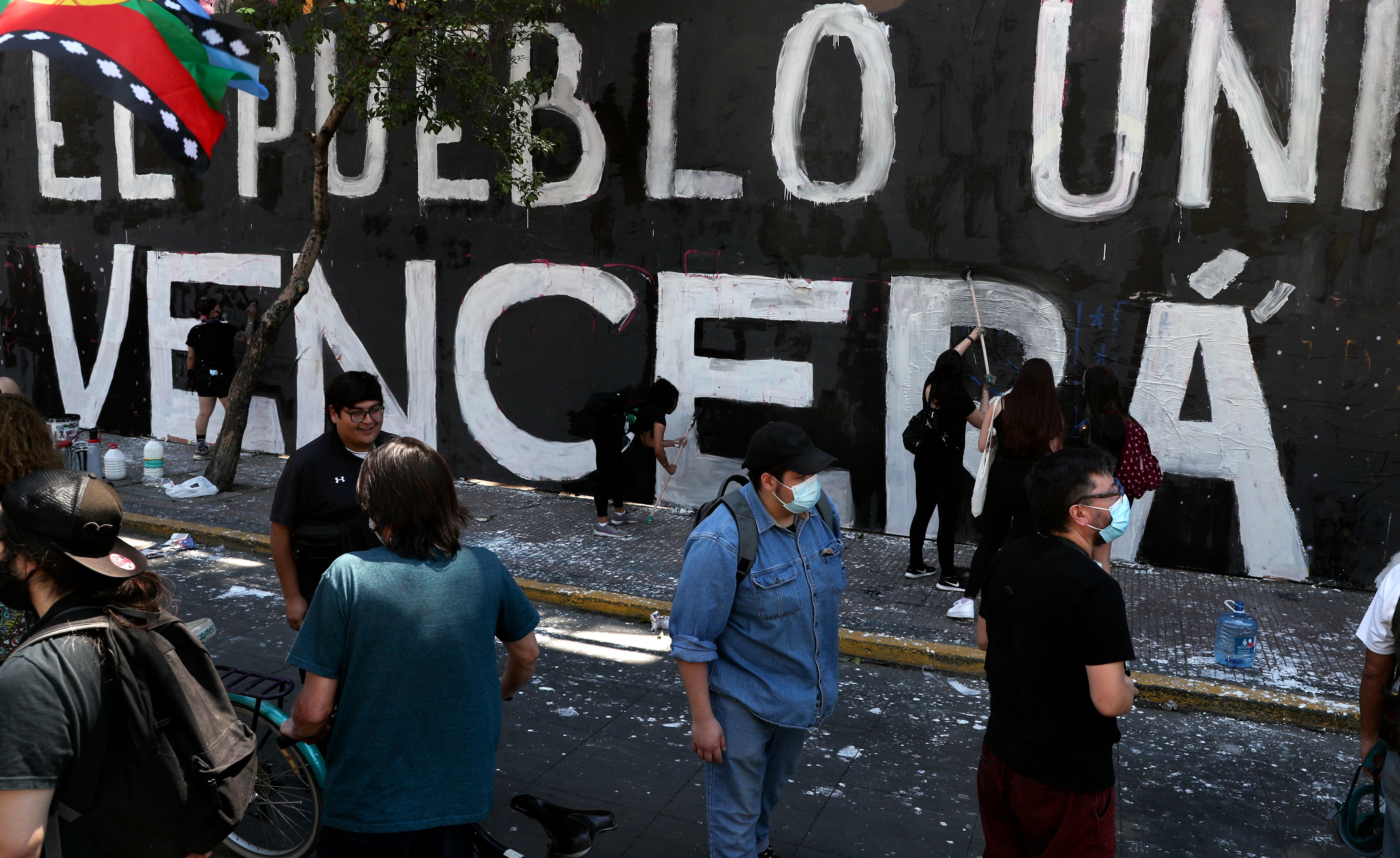 Manifestantes pintan una pared mientras conmemoran el aniversario del estallido social de 2019 en protesta a un incremento en las tarifas del metro en Santiago de Chile el domingo 28 de octubre de 2020.&nbsp;