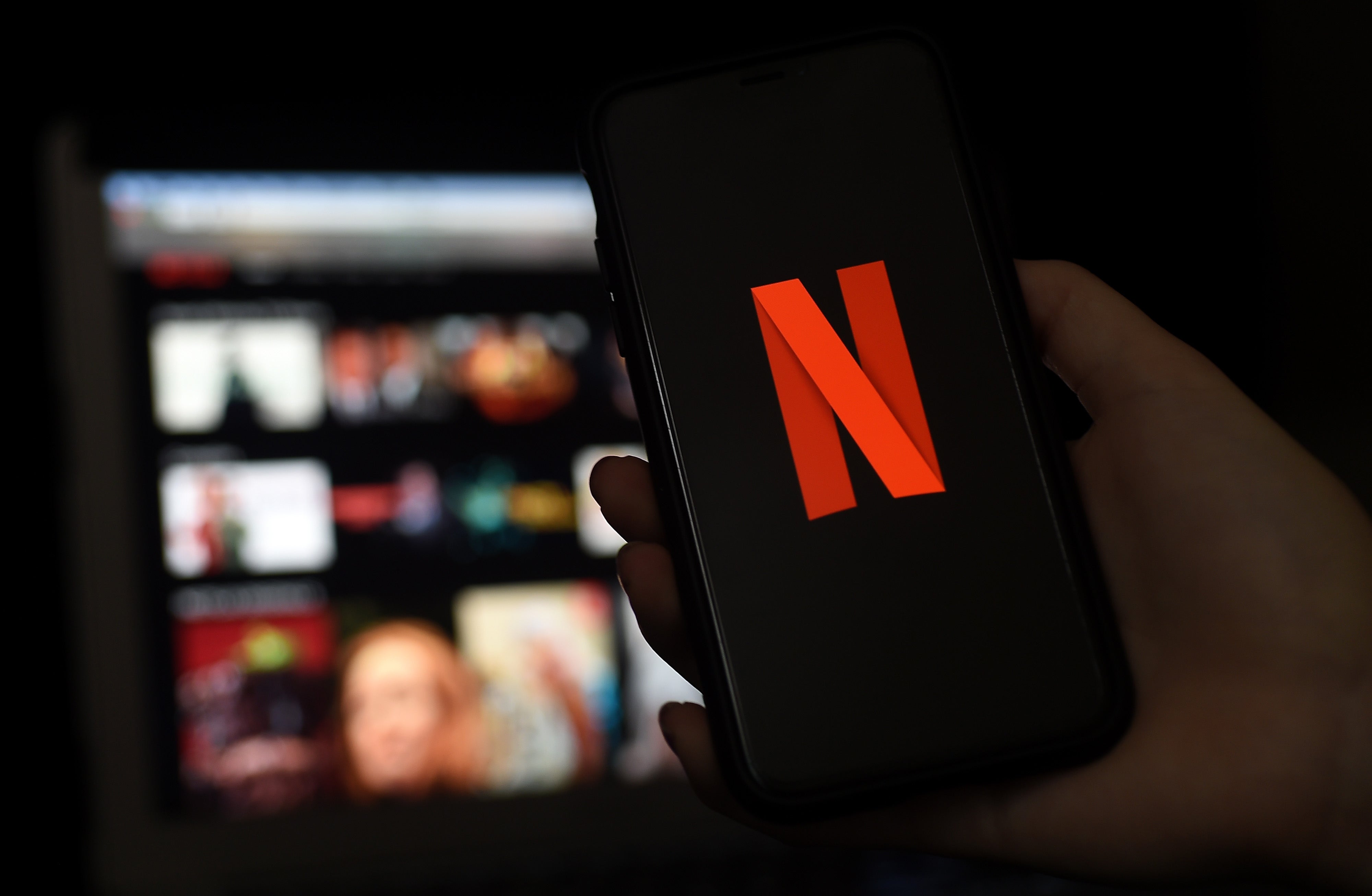 Las pantallas de una computadora y un teléfono móvil muestran el logo de Netflix el 31 de marzo de 2020 en Arlington, Virginia.