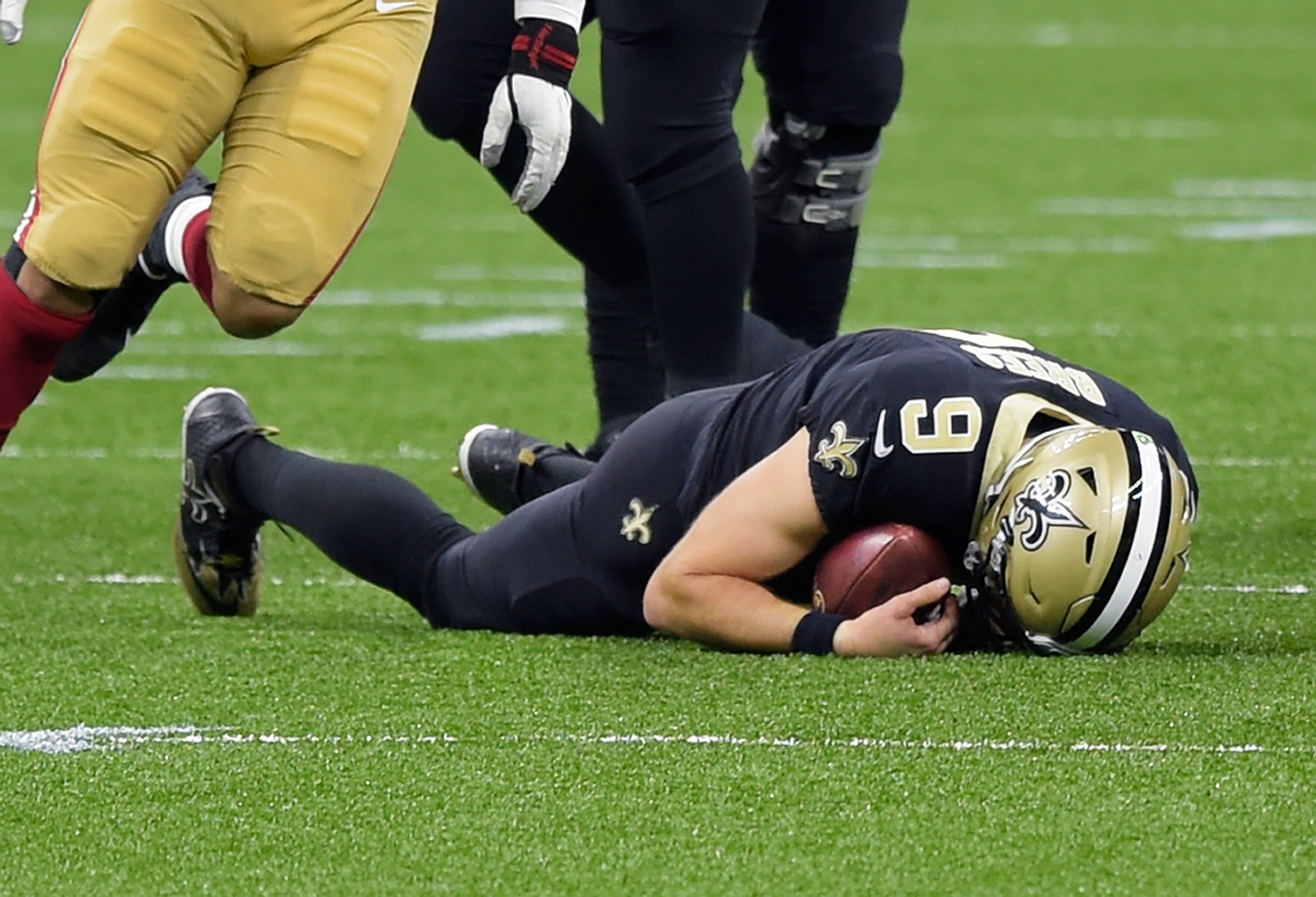 El quarterback de los Saints de Nueva Orleans, Drew Brees, en el suelo tras ser capturado por Kentavius Street de los 49ers de San Francisco durante el segundo cuarto del partido de la NFL, en Nueva Orleans, el domingo 15 de noviembre de 2020.