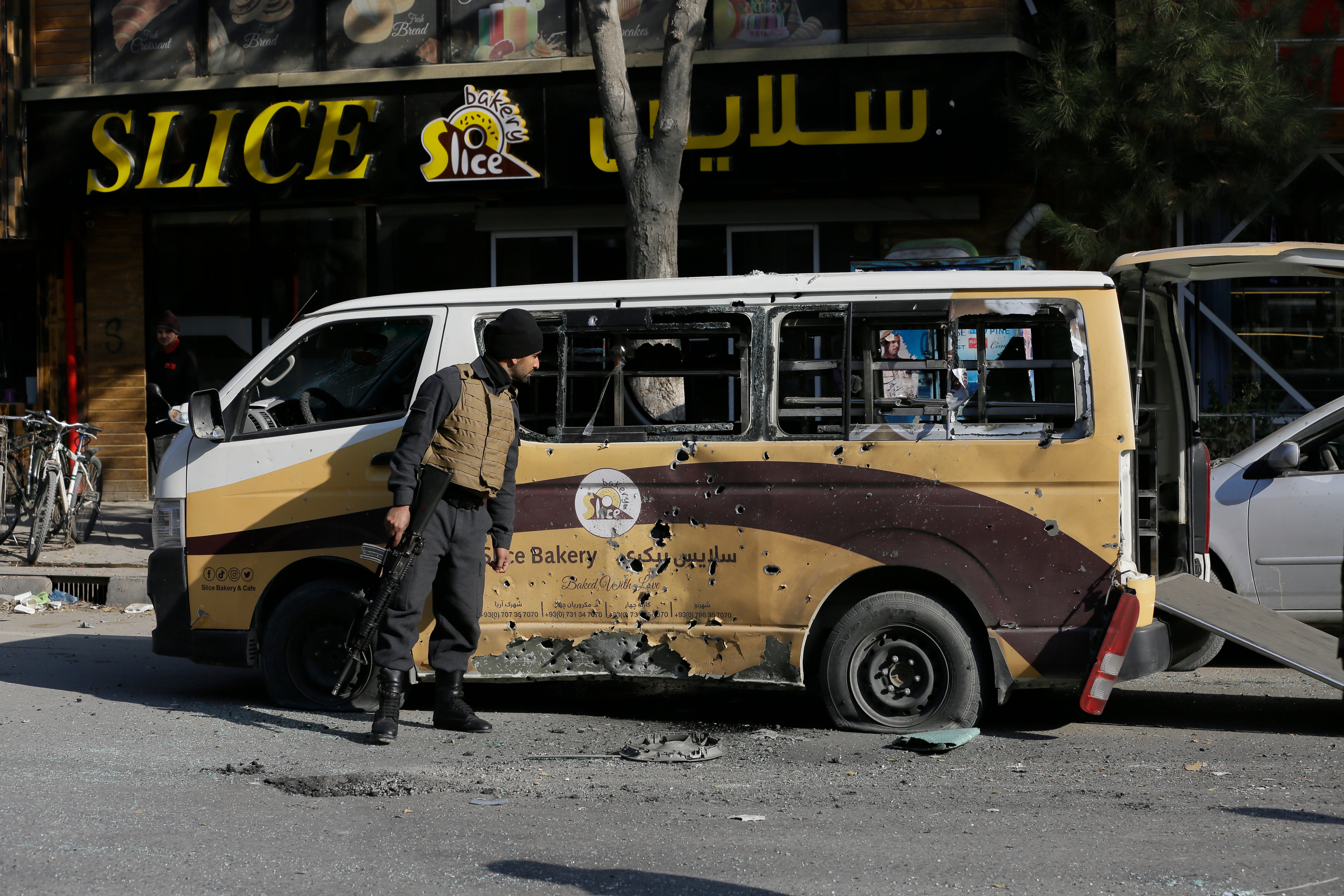 Un miembro de las fuerzas de seguridad de Afganistán revisa un auto destrozado por un ataque con mortero en Kabul, Afganistán, el 21 de noviembre de 2020.