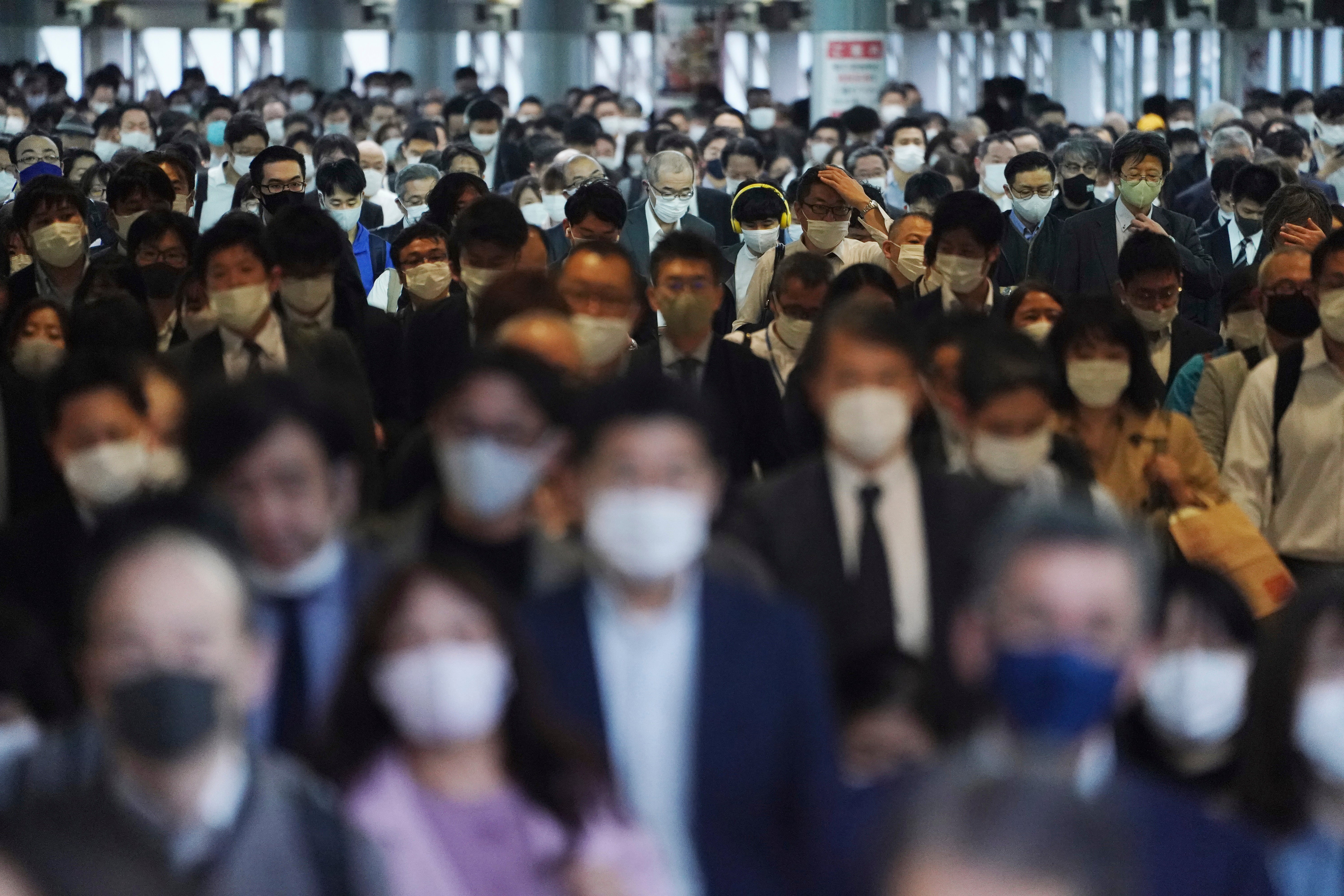 Centenares de pasajeros con mascarillas caminan por el pasillo de una estación de transporte colectivo durante una hora pico en Tokio el viernes 20 de noviembre de 2020.