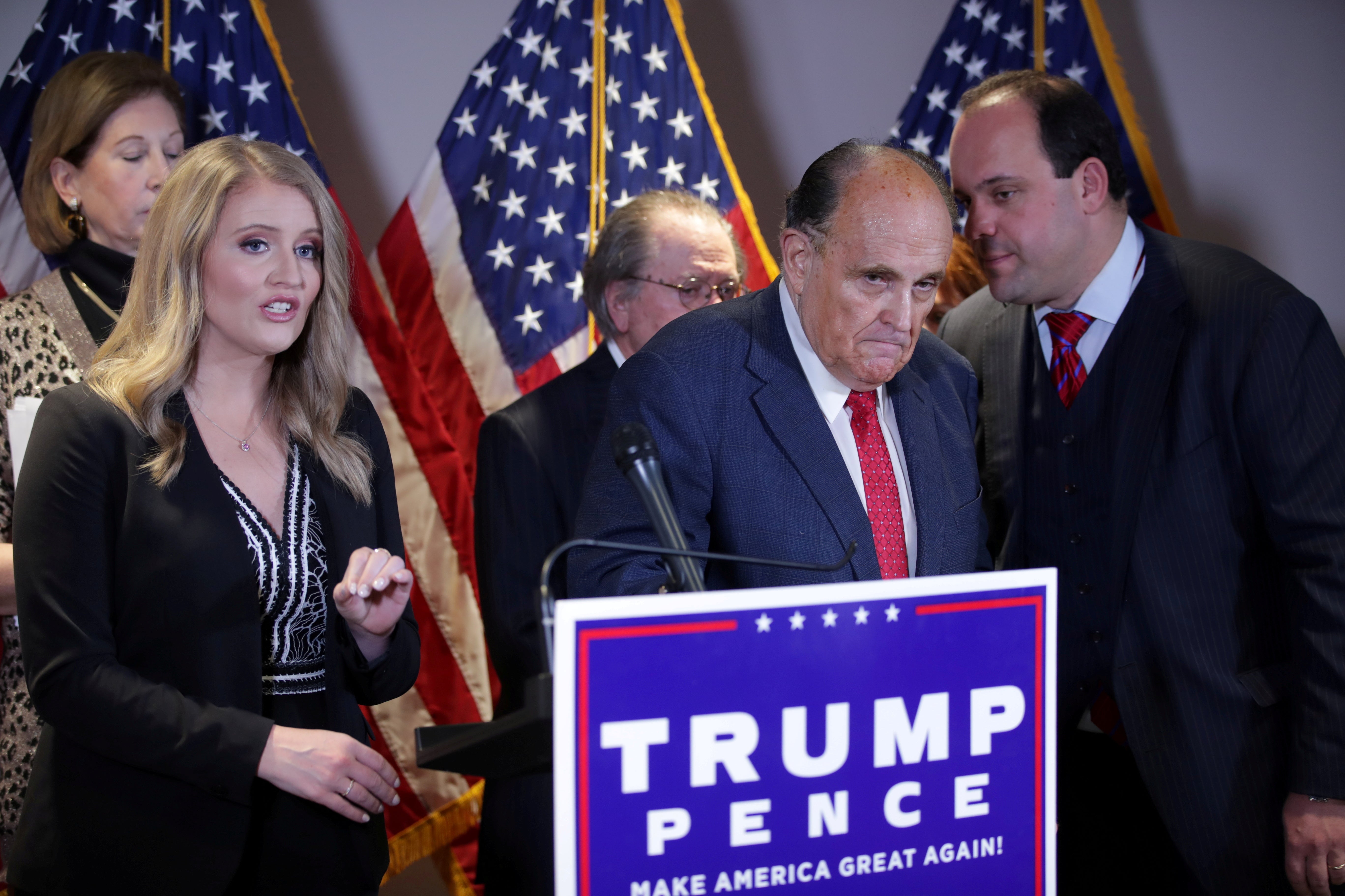 El asesor de campaña de Trump, Boris Epshteyn, le susurra a Rudy Giuliani durante una conferencia de prensa en la sede del Comité Nacional Republicano en Washington DC el 19 de noviembre.