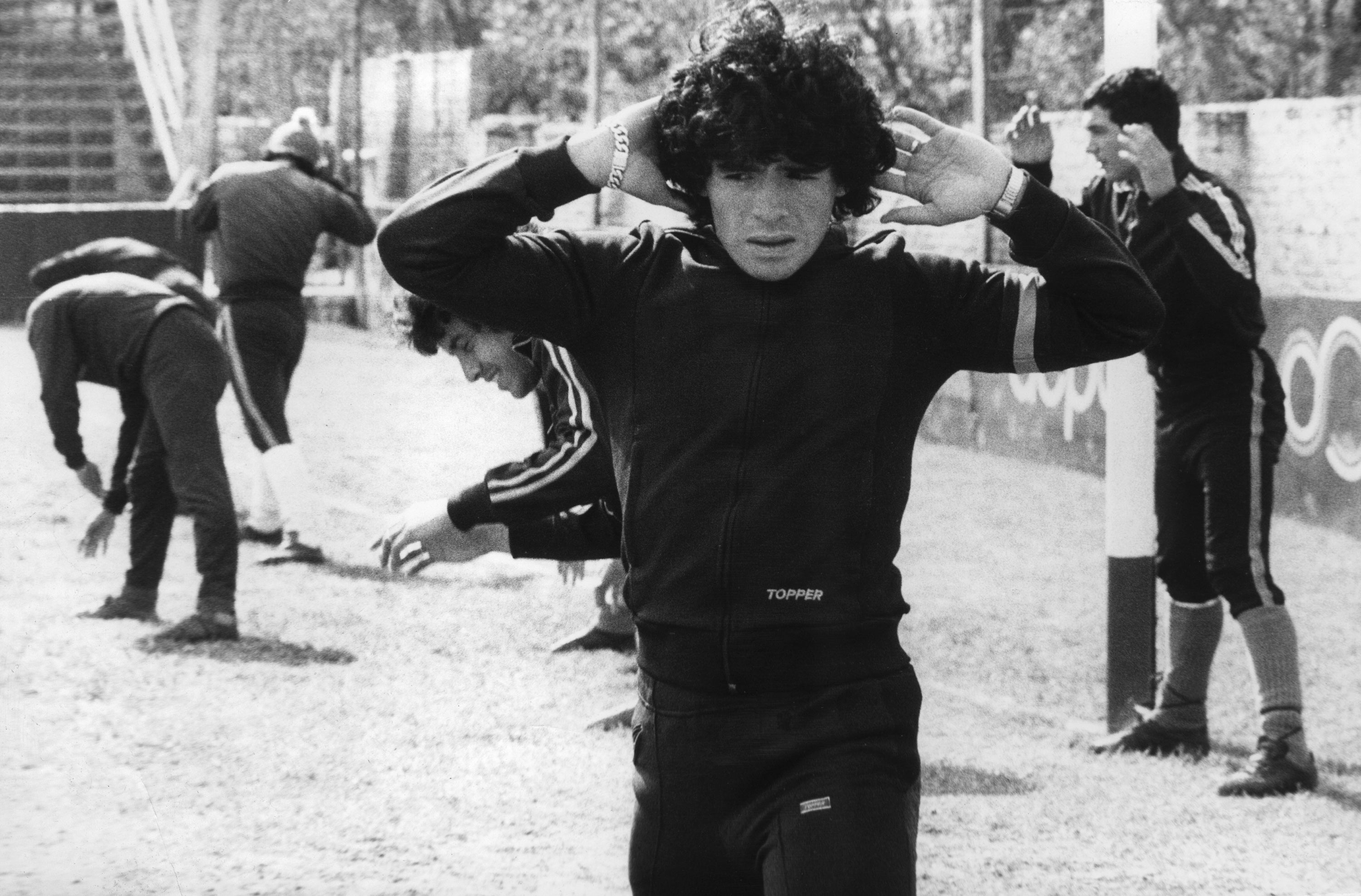 Diego Maradona, 16 años, calienta el 12 de septiembre de 1977 en Buenos Aires. Maradona nació el 30 de octubre de 1960 en Villa Fiorito, uno de los suburbios más pobres de Buenos Aires. La mayoría de la gente lo considera el mejor jugador de fútbol de la historia. Empezó a jugar cuando tenía 9 años. Su primer club fue el Cebollitas, el equipo juvenil de Argentinos Juniors. Debido a su talento desconocido, pronto obtuvo el apodo “Pibe de Oro”, que literalmente significa “Golden Boy”. Jugó hasta los 15 años para el equipo juvenil. A los 16 años debutó en el fútbol profesional con Argentinos Juniors. Y unos meses después ya debutó en la selección de Argentina.&nbsp;