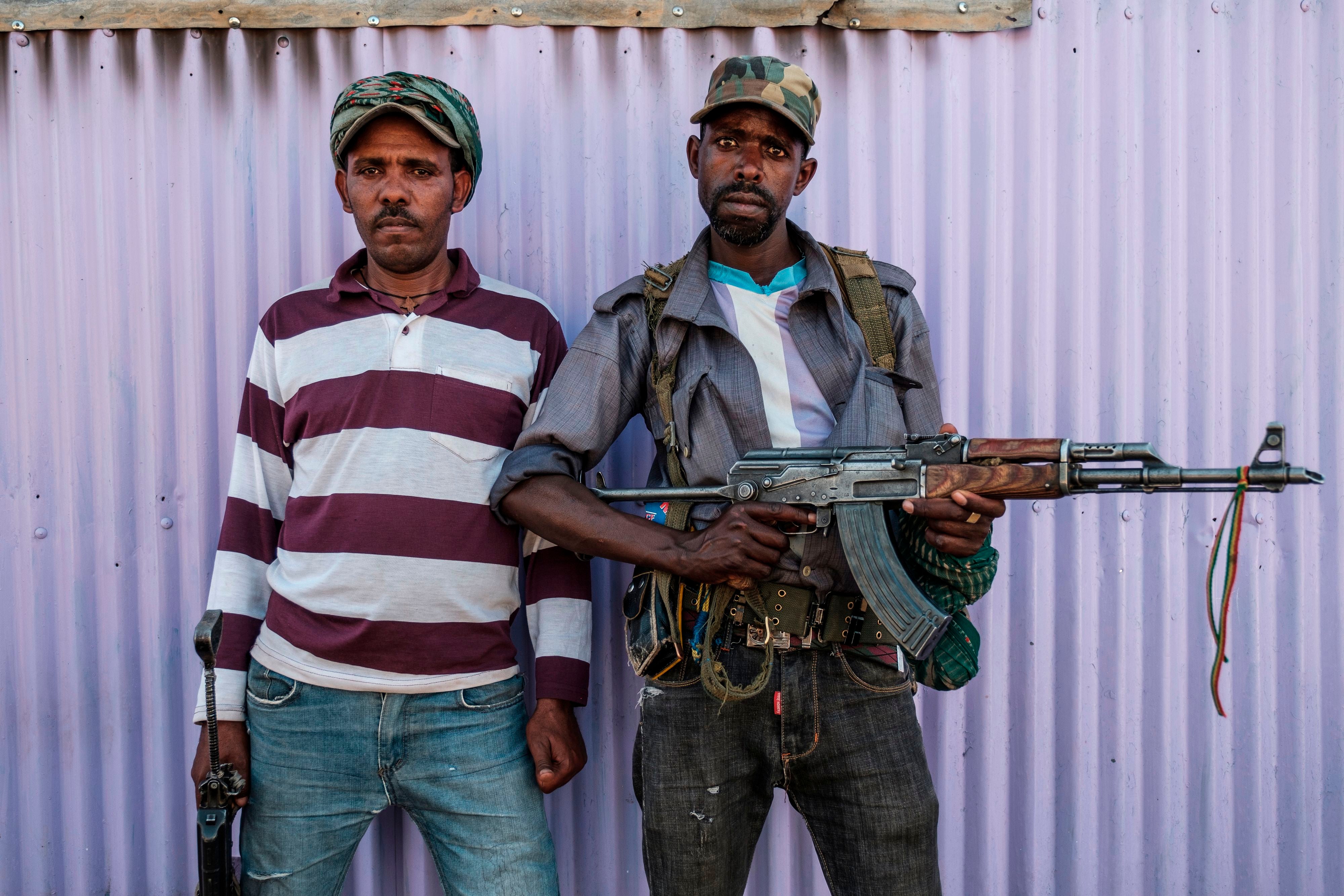 Dos miembros de la milicia de Amhara posan para una foto, en Mai Kadra, Etiopía, el 21 de noviembre de 2020. - Amharas y Tigrayans eran vecinos incómodos antes de los actuales combates, con la tensión sobre la tierra que provocó violentos enfrentamientos. El hecho de que Mai-Kadra esté siendo dirigido ahora, al menos temporalmente, por Amharas proporciona alivio a los Amharas, incluso mientras profundiza los temores de los tigres de la ocupación.