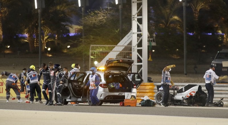 El piloto Romain Grosjean del equipo Haas recibe auxilio tras estrellar su monoplaza en el Gran Premio de Bahréin.