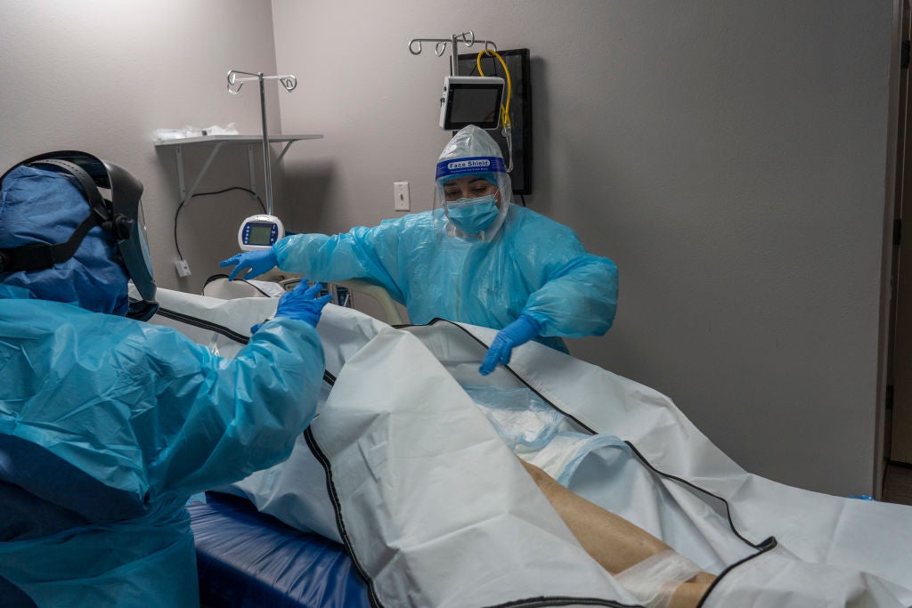 Personal médico en un hospital en Houston, Texas, cierra la bolsa para cadáveres de un paciente fallecido con Covid-19