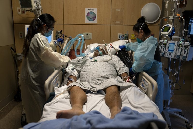 ARCHIVO — En esta fotografía de archivo del 19 de noviembre de 2020, las enfermeras Karen Ross, derecha, y Angela Nguyen atienden a un paciente enfermo de COVID-19 en el Centro Médico Providence Holy Cross, en el sector Mission Hills de Los Ángeles.