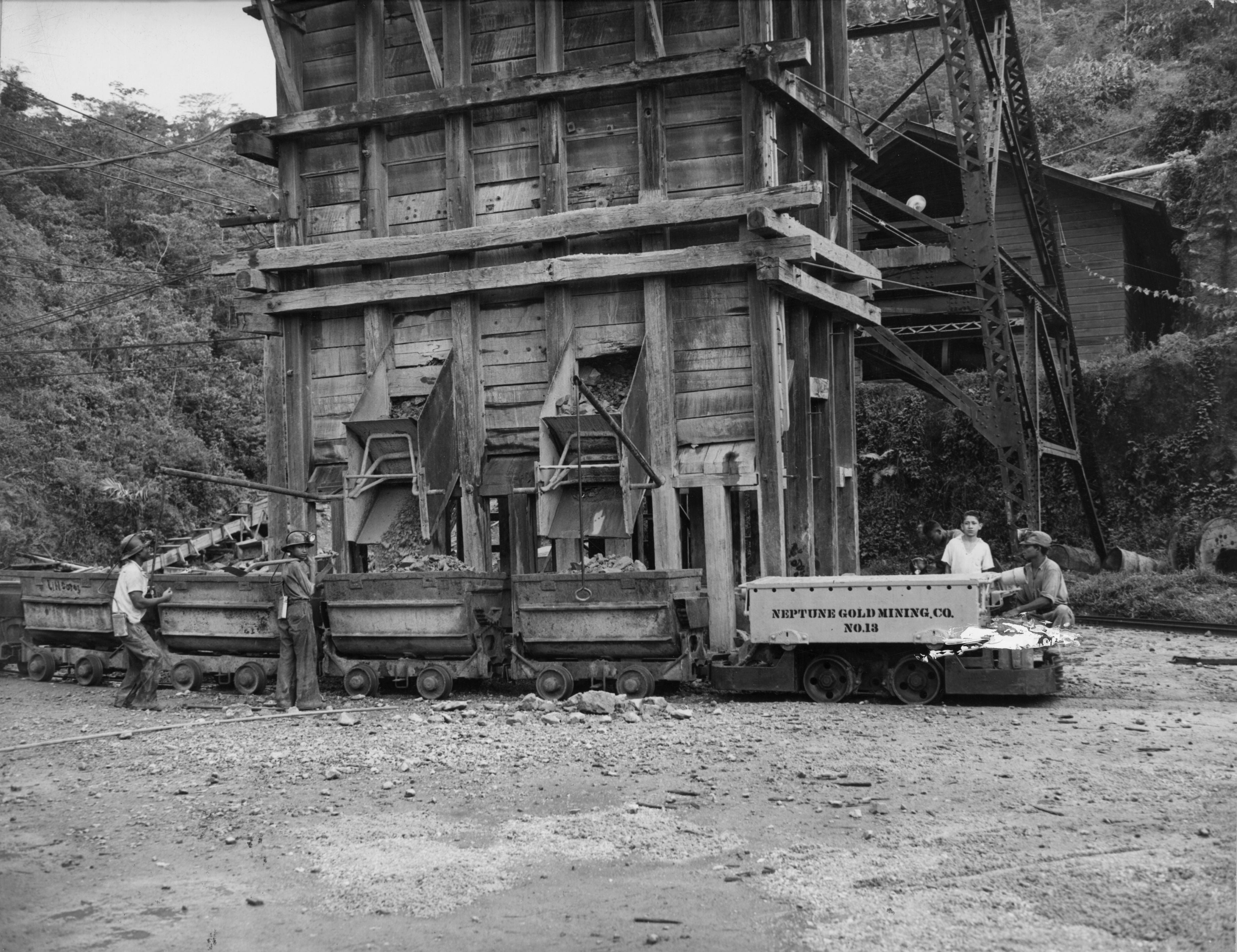 ARCHIVO- alrededor de 1955: En la mina de oro Bonanza en Nicaragua, las rocas se deslizan por toboganes desde el pozo de mineral en una fila de carros.