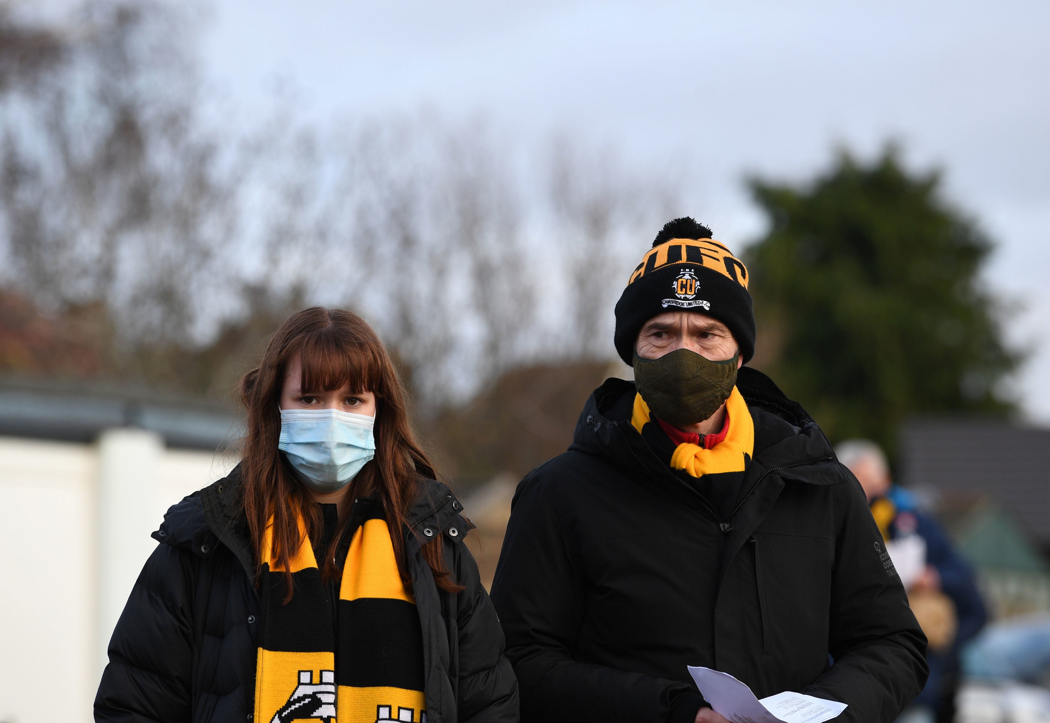 Los fanáticos llegan portando cubrebocas para ver un partido de fútbol en el Abbey Stadium de Cambridge, el 5 de diciembre de 2020.