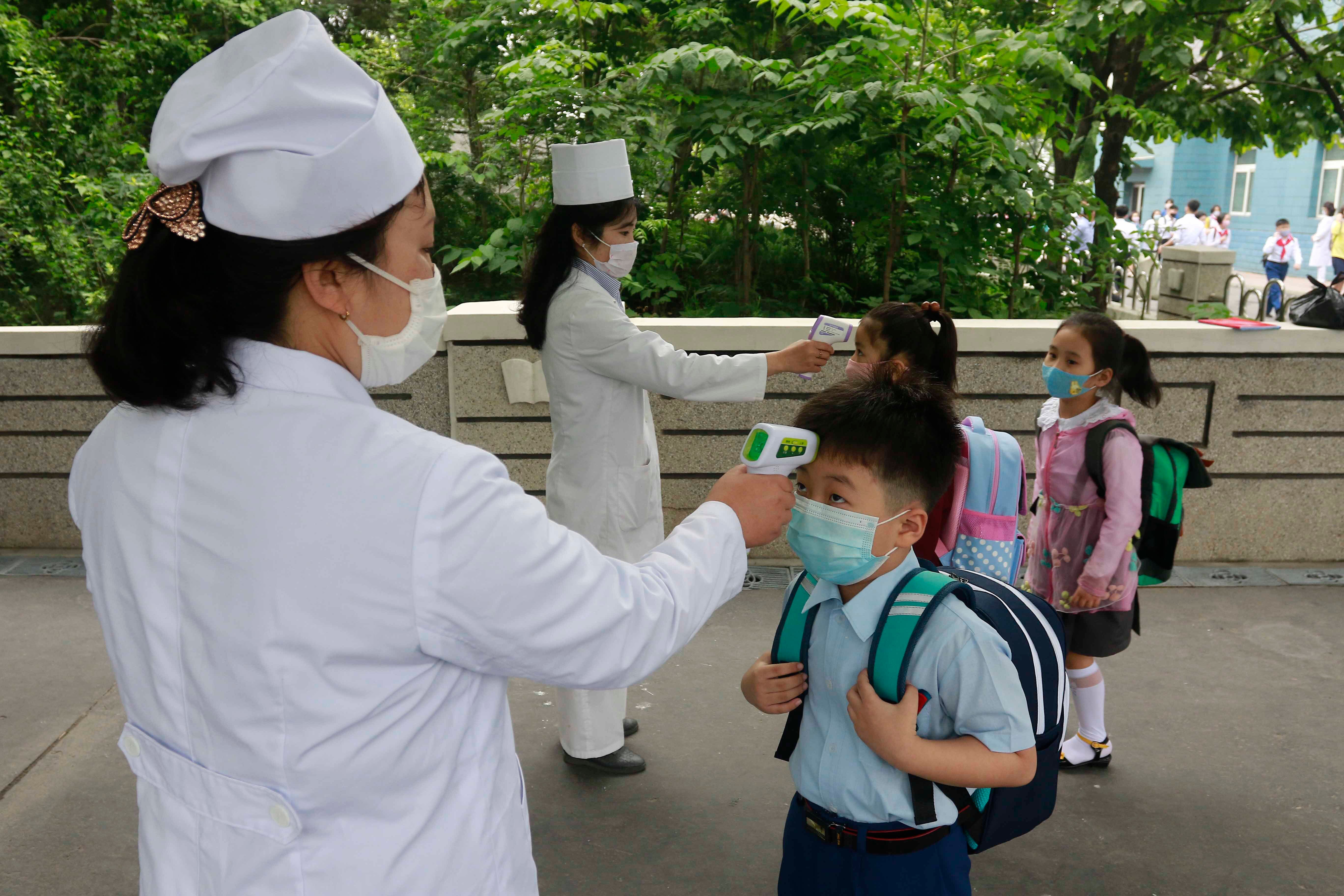 Enfermeras le toman la temperatura a los alumnos en una escuela en Pyongyang, la capital de Norcorea, el 3 de junio del 2020. &nbsp;