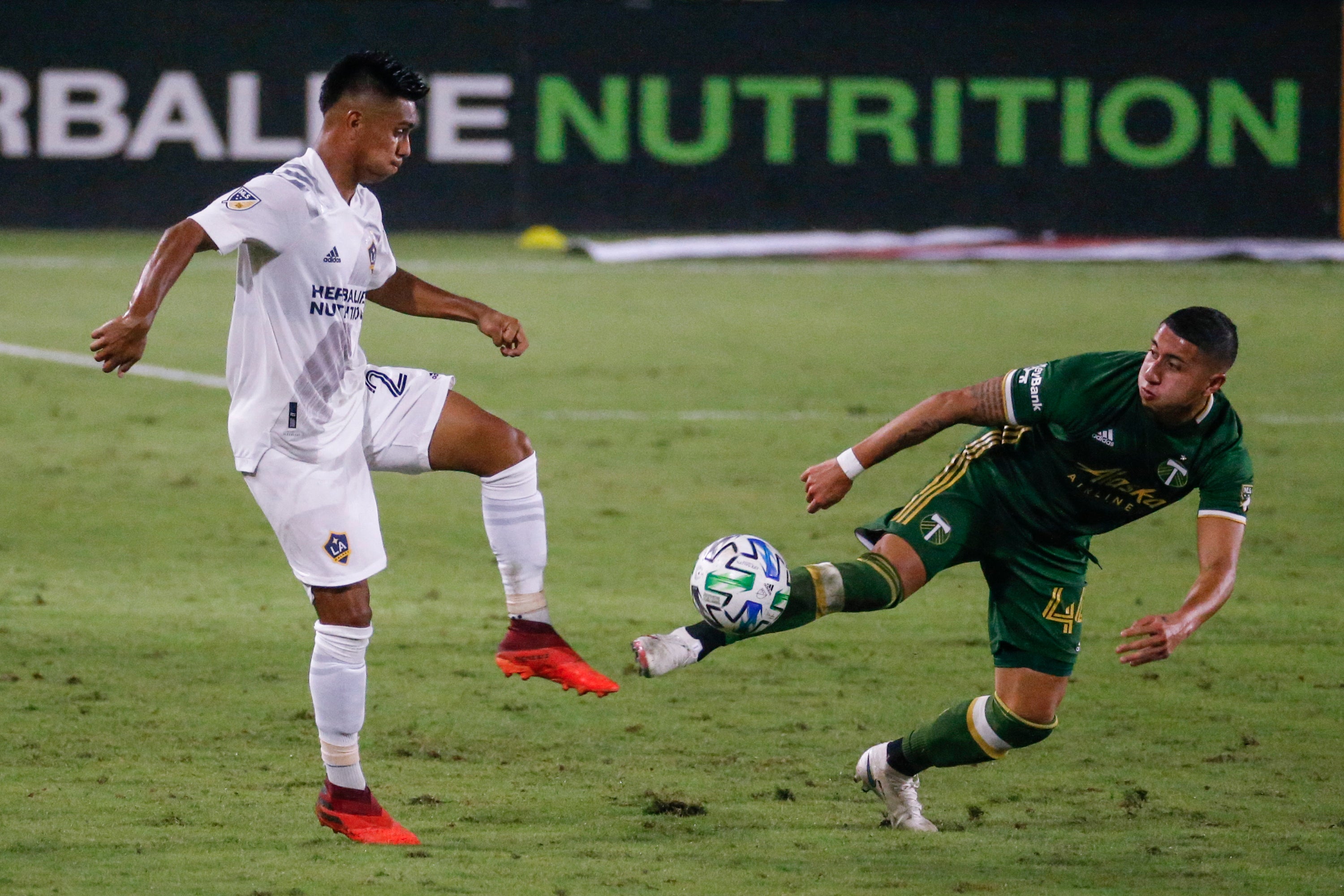 Efraín Álvarez del Galaxy de Los Ángles y Marvin Loria de Portland pugnan por balón en el partido de la MLS en Carson, California.&nbsp;