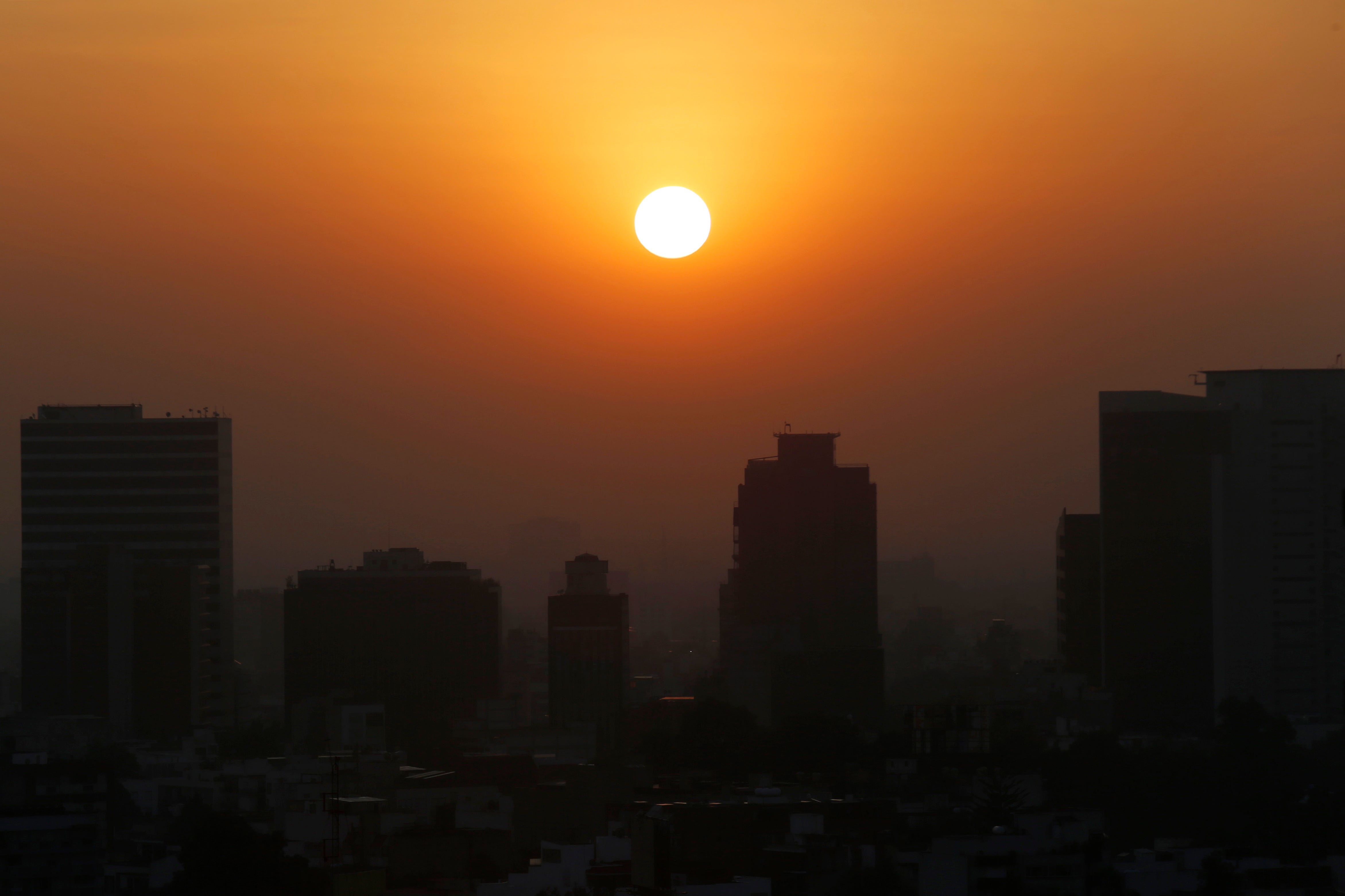 ARCHIVO - En esta foto del 20 de febrero del 2020, el sol se alza entre el smog de la Ciudad de México. Cinco años después de un histórico en París, los líderes mundiales se reúnen de nuevo para aumentar sus esfuerzos contra el calentamiento global.&nbsp;