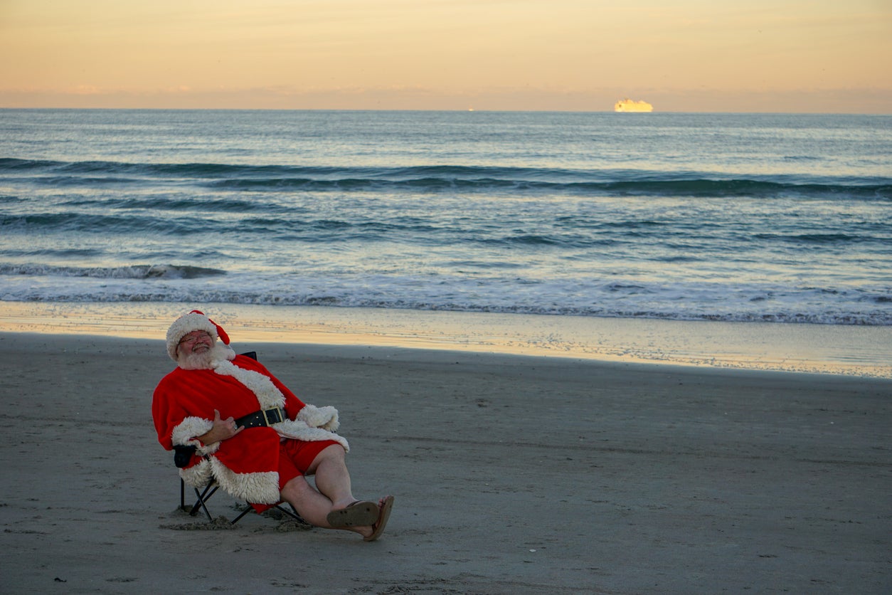 Vacaciones en Cocoa Beach Santa Claus relajándose y sonriendo.
