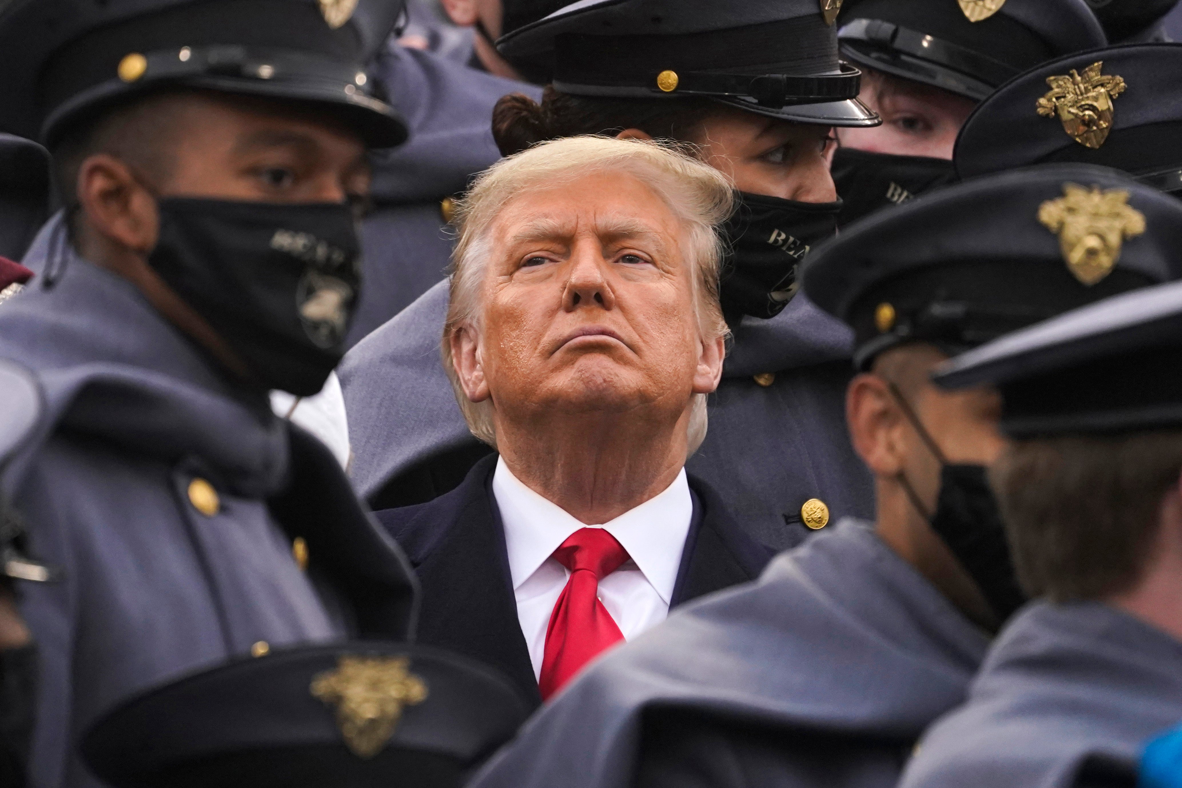 Rodeado de cadetes del ejército, el presidente Donald Trump observa la primera mitad del 121 ° partido de fútbol entre el ejército y la Marina en el estadio Michie de la Academia Militar de los Estados Unidos, el sábado 12 de diciembre de 2020, en West Point, Nueva York.