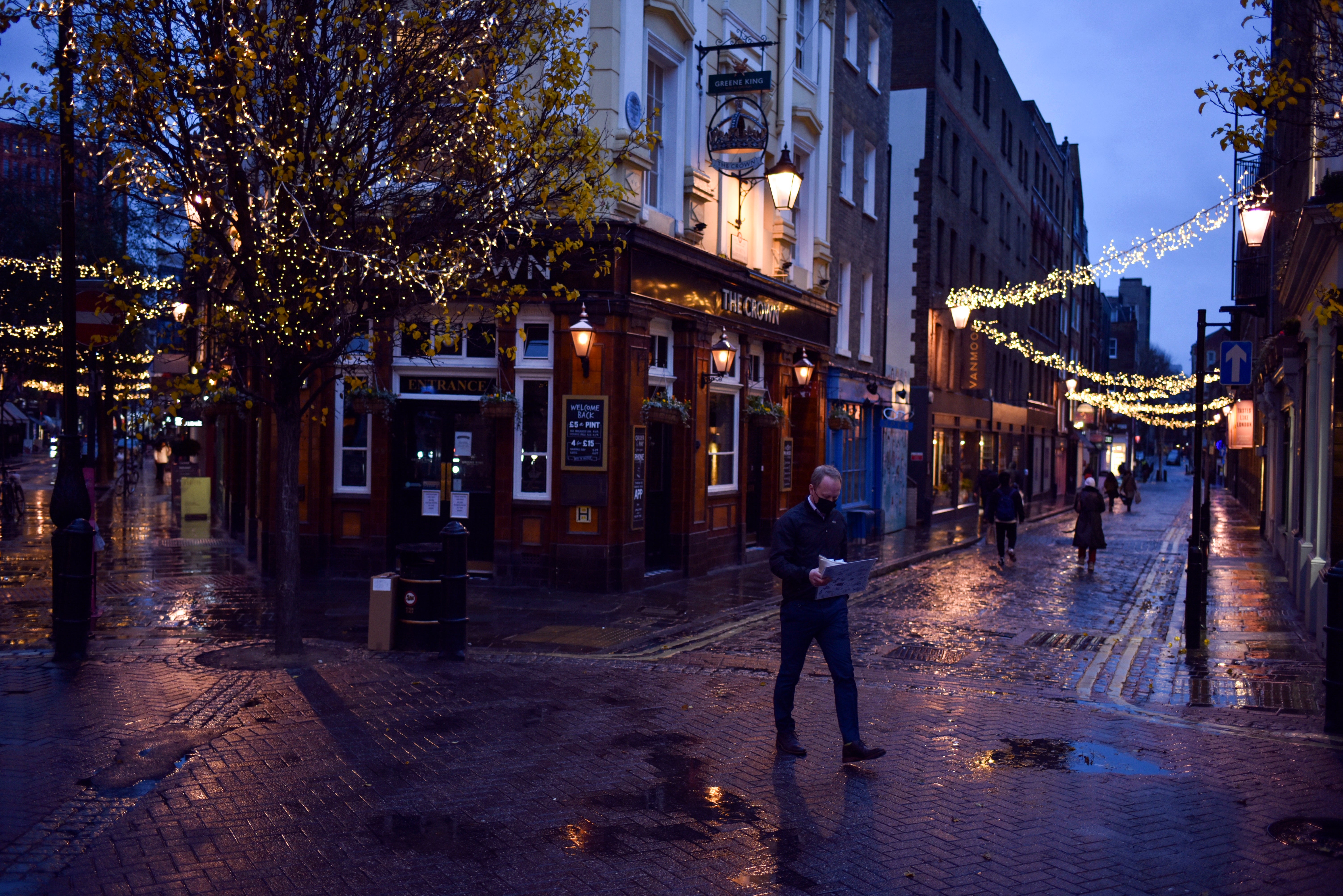 Un hombre con mascarilla camina frente a un pub cerrado en la zona Seven Dials de Covent Garden, en Londres, el miércoles 16 de diciembre de 2020.&nbsp;