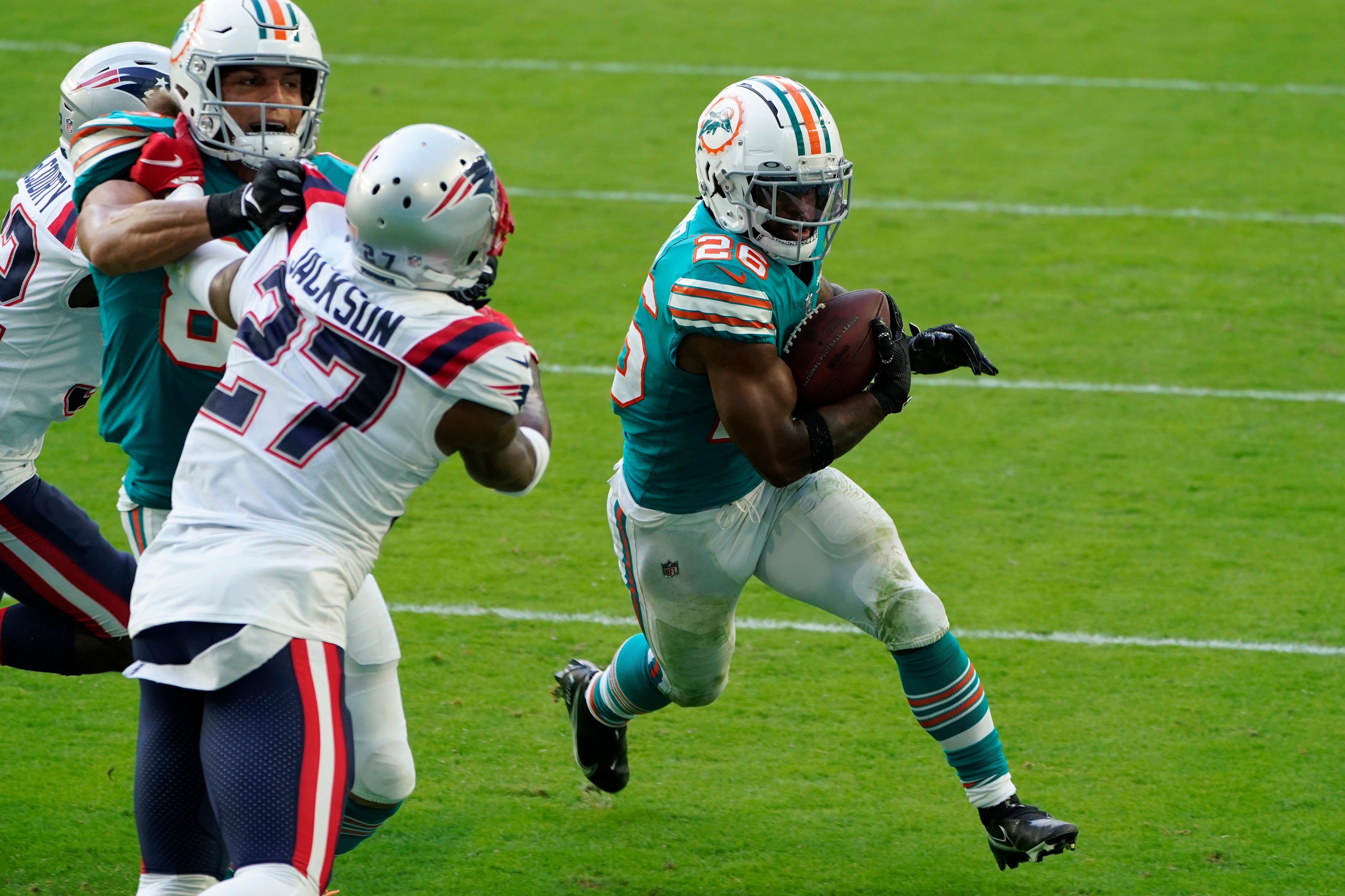El corredor novato de los Dolphins de Miami Salvon Ahmed corre para la conversión de dos puntos en el encuentro ante los Patriots.