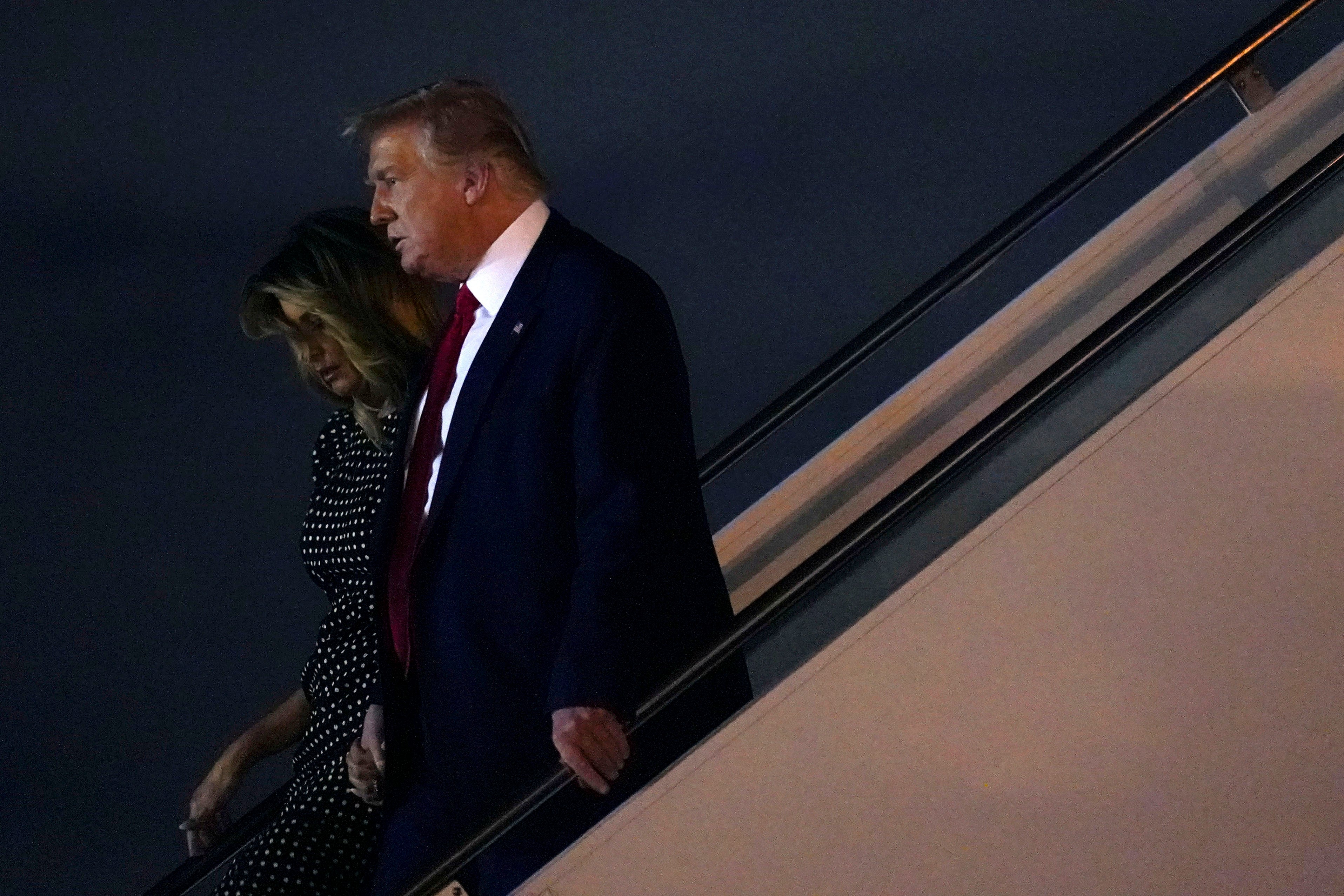 El presidente Donald Trump y la primera dama Melania Trump descienden del avión presidencial.