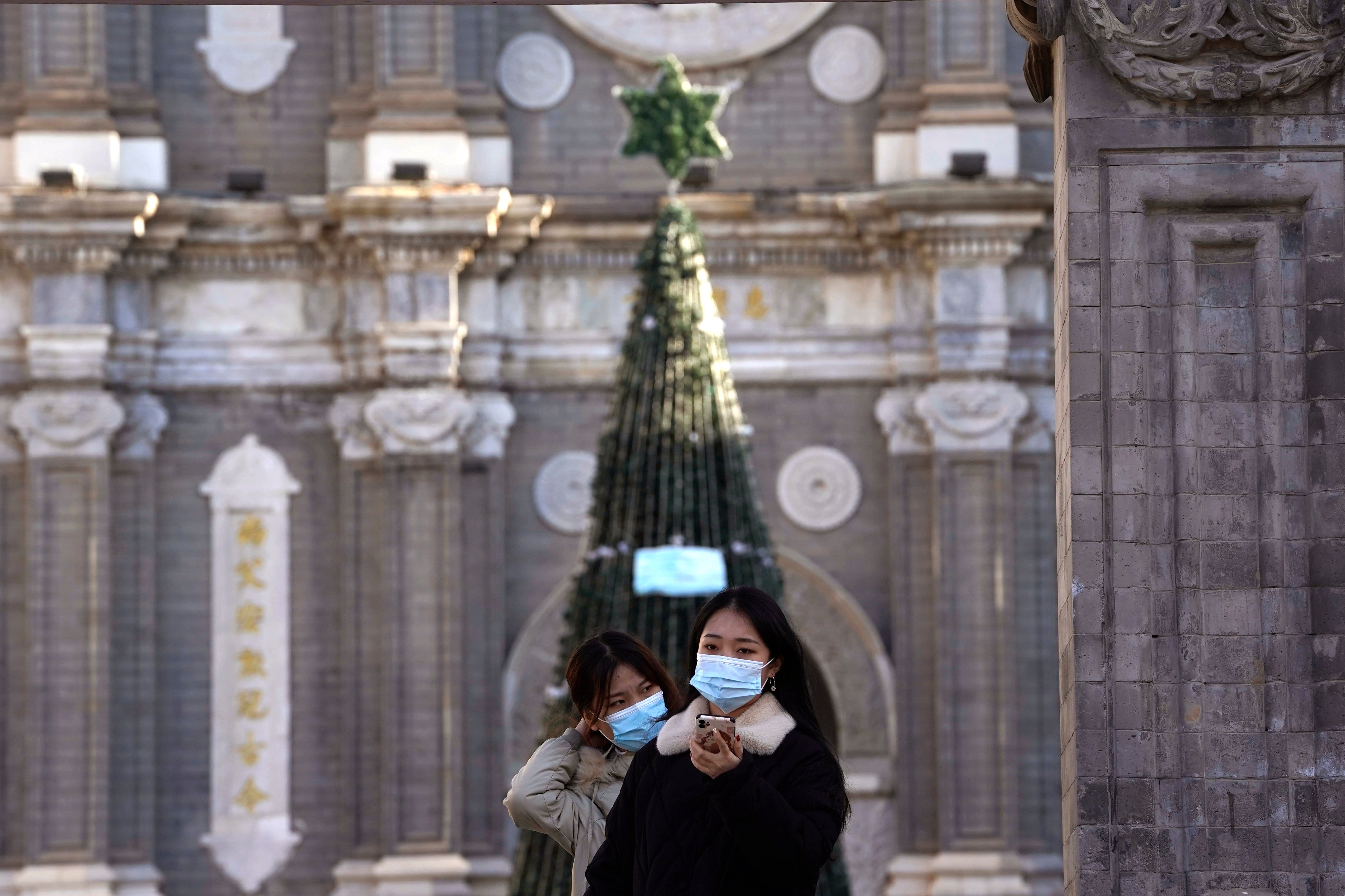 Unas personas posan para una fotografía afuera de la iglesia de Wangfujing, en Beijing, el viernes 25 de diciembre de 2020.&nbsp;