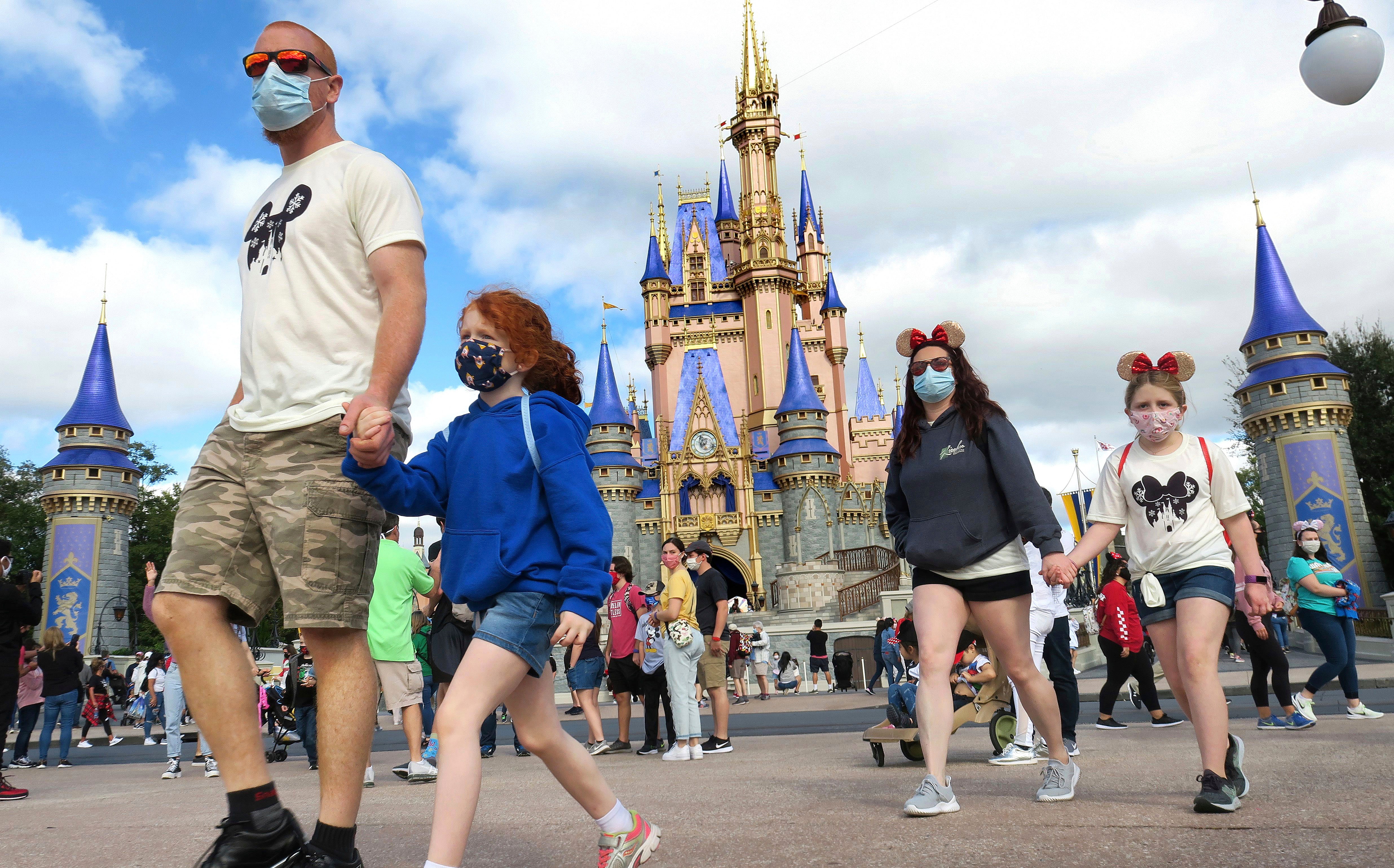 Personas pasean en Disneyland mientras utilizan su cubrebocas como medida de seguridad.&nbsp;