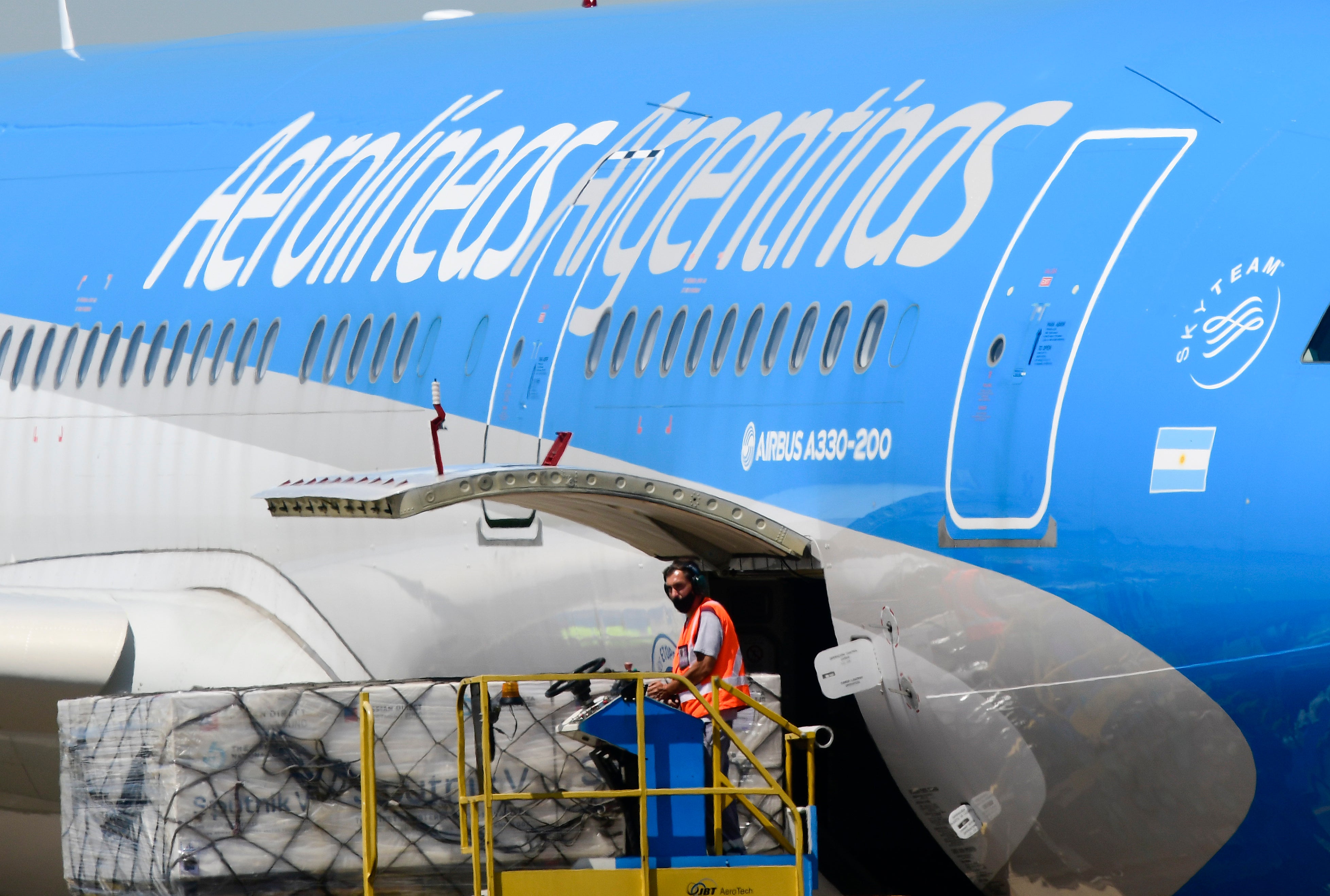 Un trabajador descarga el primer envío de la vacuna rusa Sputnik V contra el COVID-19 de un avión en el Aeropuerto Internacional en Buenos Aires, Argentina, el jueves 24 de diciembre de 2020.&nbsp;