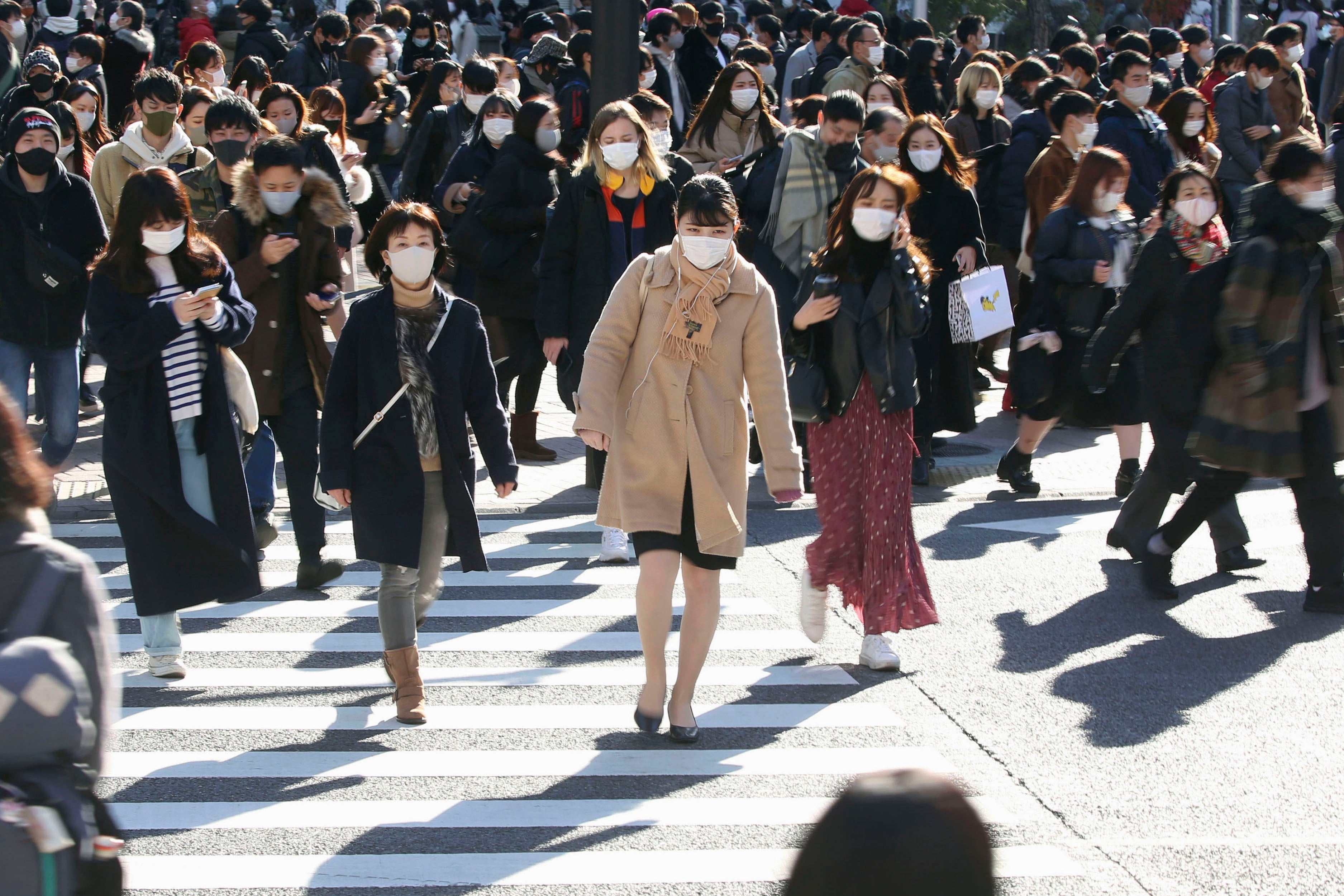 Una multitud con mascarillas para frenar la propagación del coronavirus se desplaza por una concurrida intersección en el distrito comercial de Shibuya, en Tokio, el sábado 26 de diciembre de 2020.&nbsp;