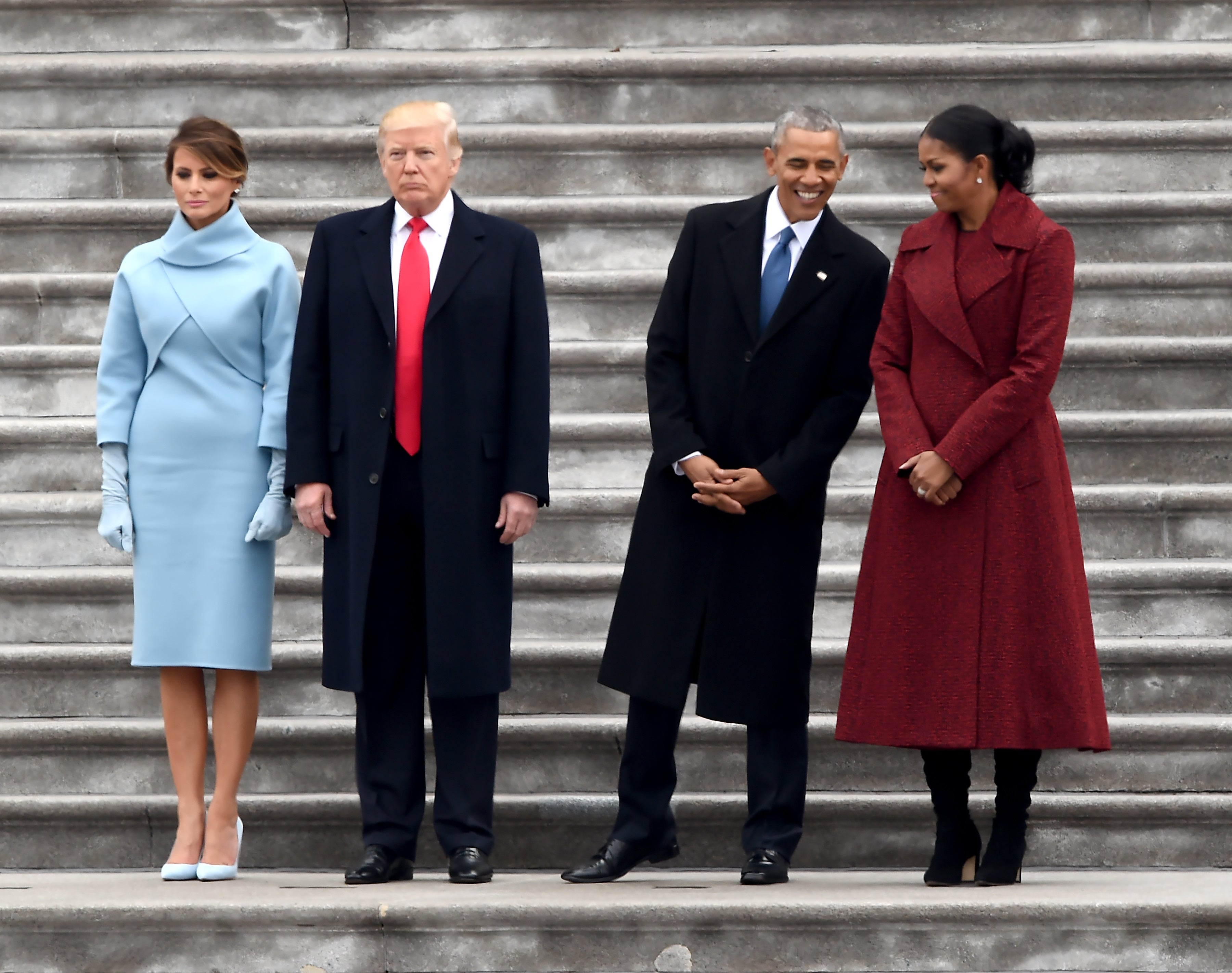 La primera dama Melania Trump, el presidente Donald Trump, el ex presidente Barack Obama y Michelle Obama se paran en los escalones del frente este del Capitolio de los Estados Unidos después de las ceremonias de inauguración el 20 de enero de 2017.