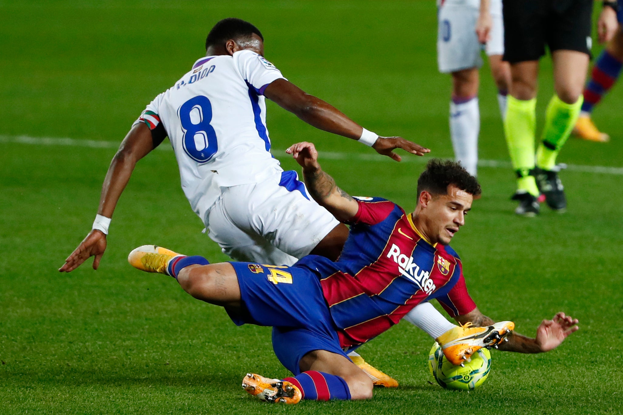 El jugador de Eibar Pape Diop derriba al atacante de Barcelona Philippe Coutinho.&nbsp;